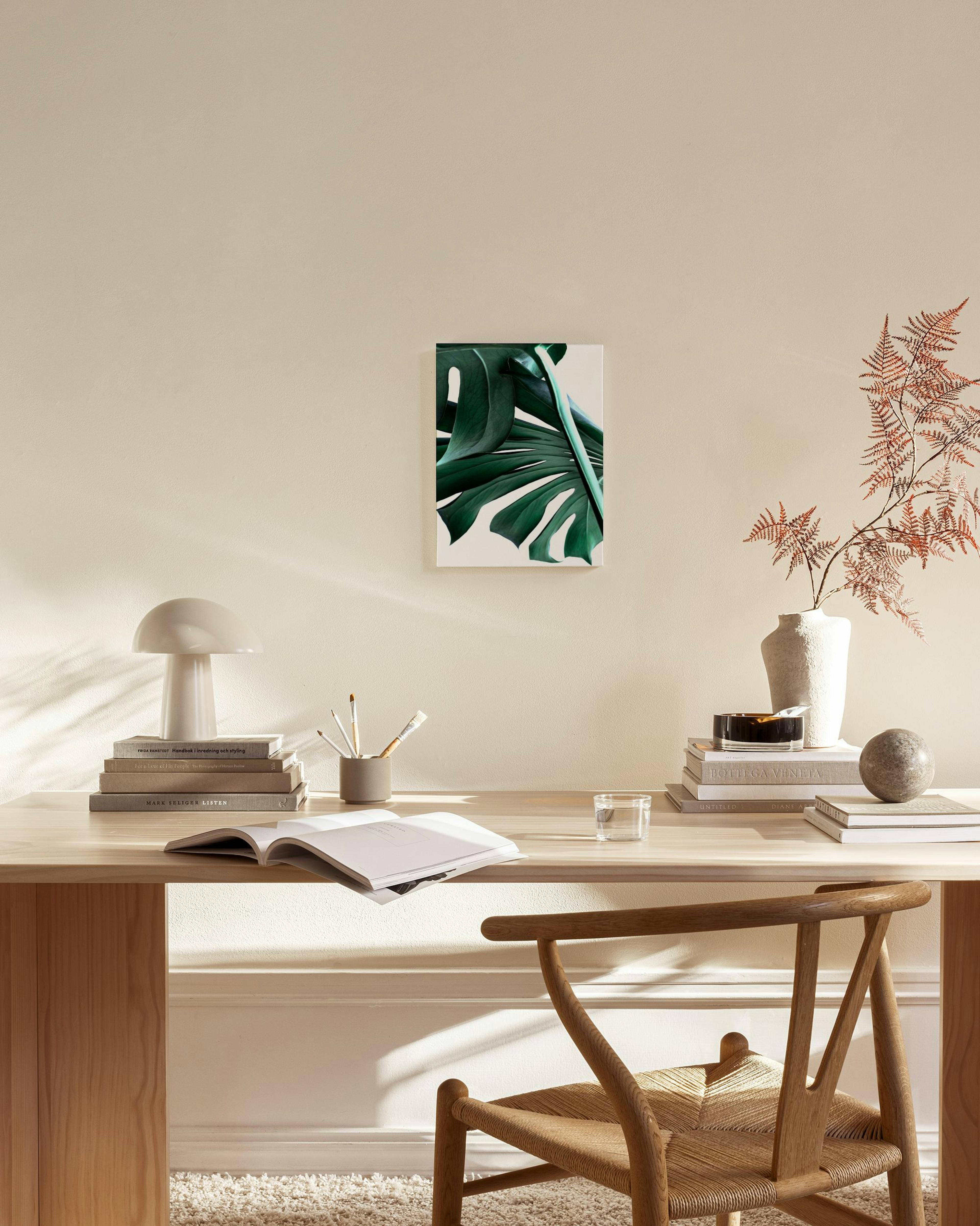 Obraz na plátne s detailom tmavozelených listov monstery, zavesený v modernom, minimalistickom interiéri.