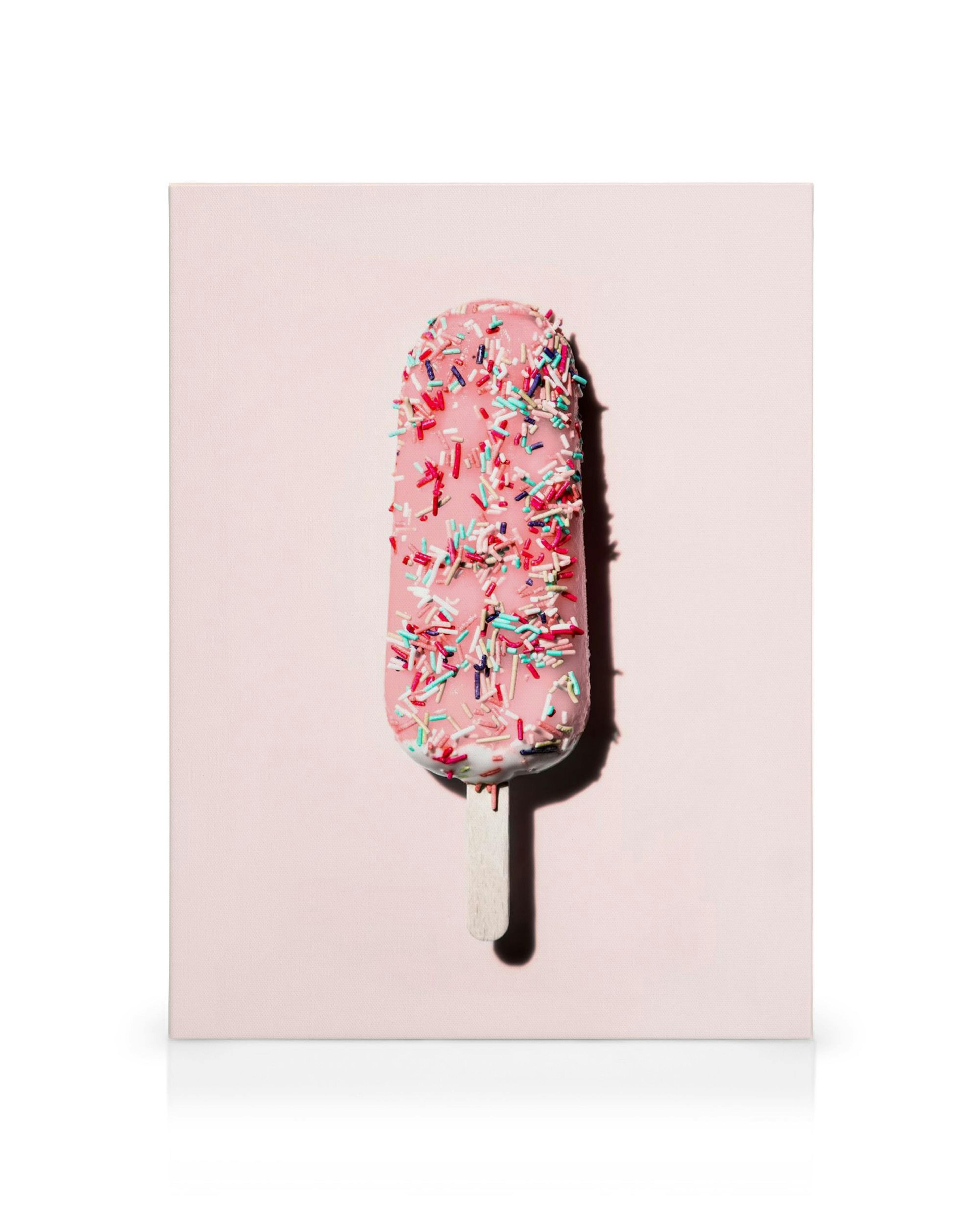 Paleta rosa vibrante con chispas de colores sobre fondo pastel, helado divertido