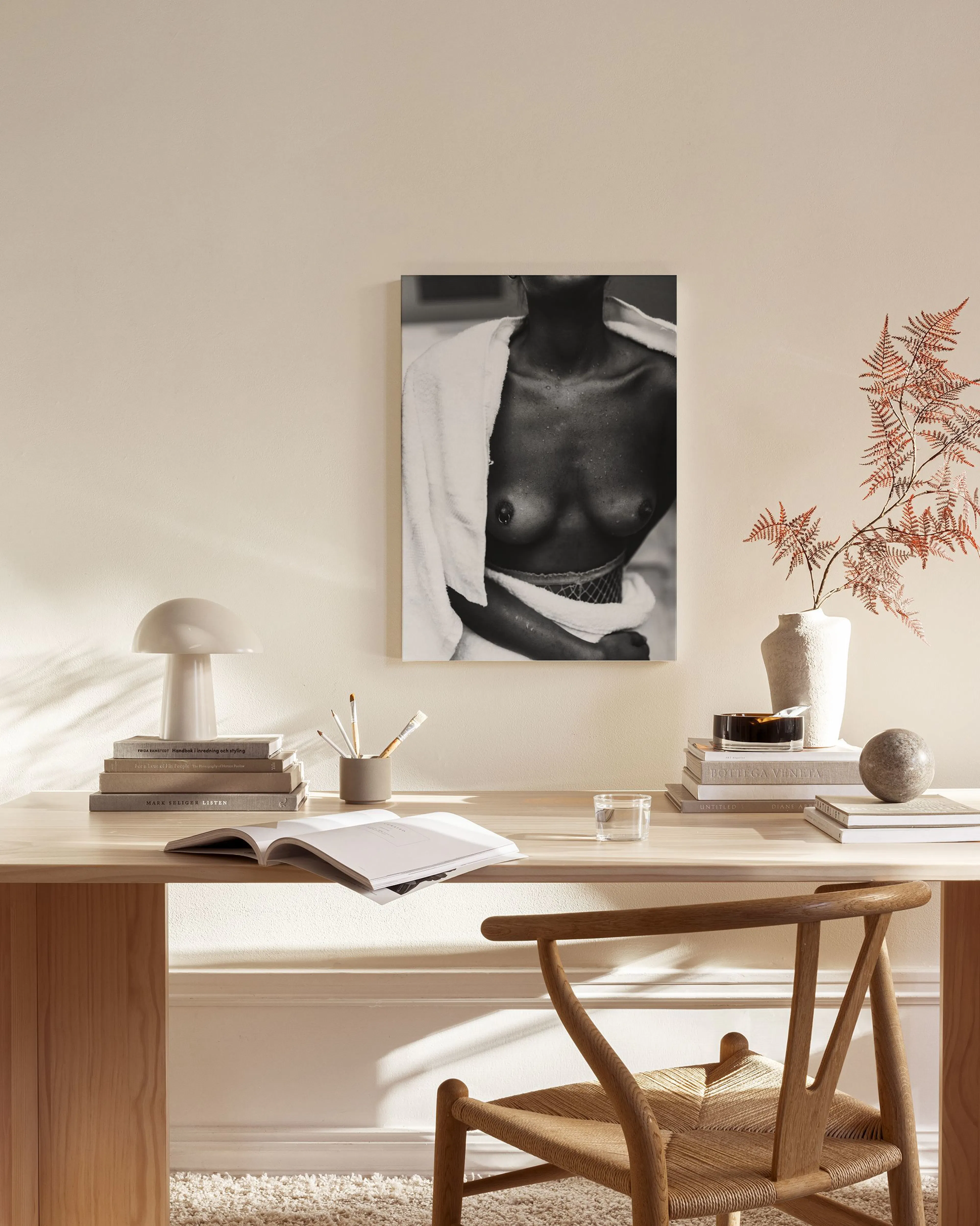 Black and white canvas print of a womans bare chest with a towel, displayed in a bright modern living room.