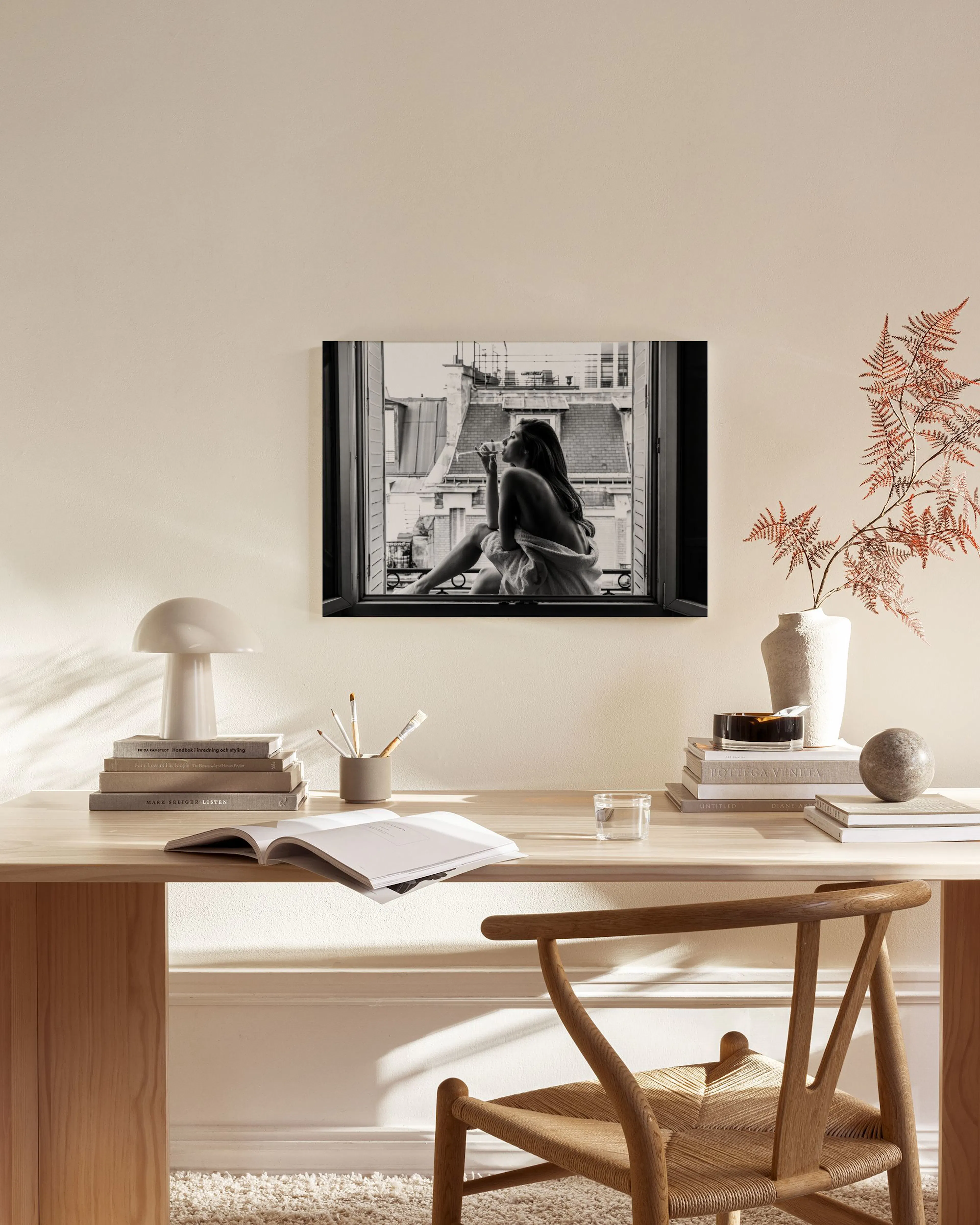 Schwarz-weißes Leinwandbild einer Frau im Fenster, in einem modernen Wohnzimmer über einem Sideboard.