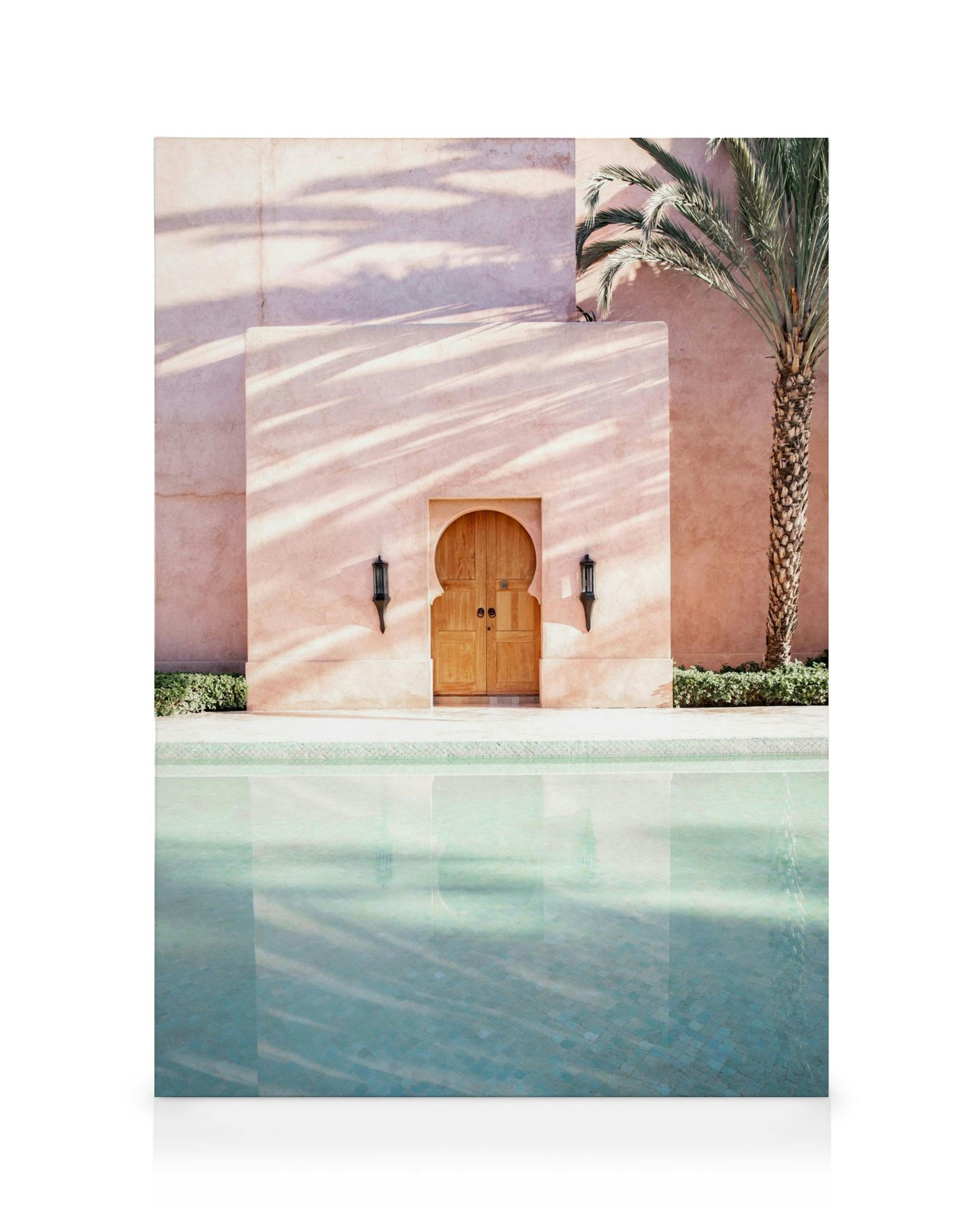 Toile dune porte voûtée rose avec lanternes, palmier et reflet dans une piscine bleue