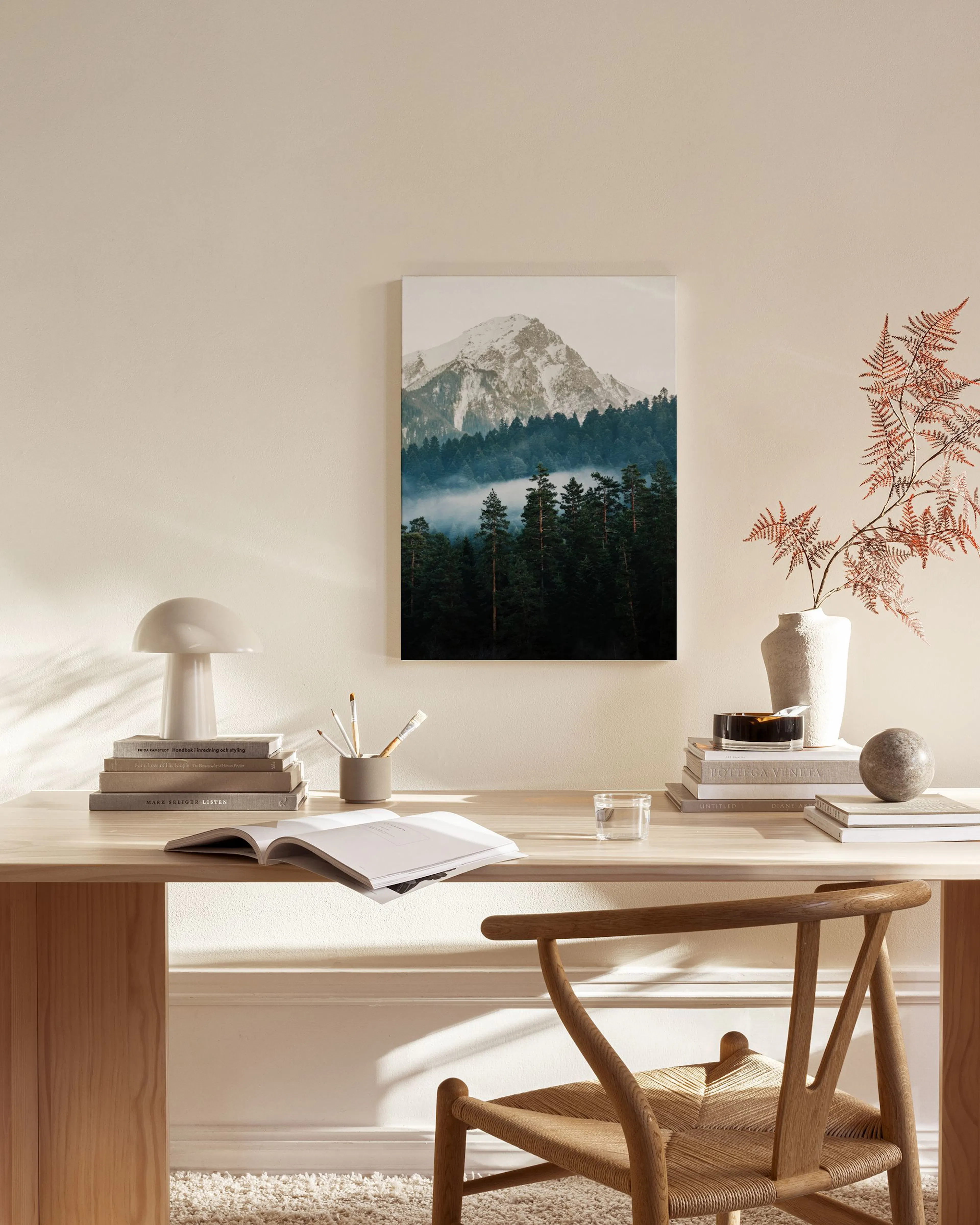 Stampa su tela di una montagna innevata e foresta, appesa in un soggiorno moderno e luminoso.