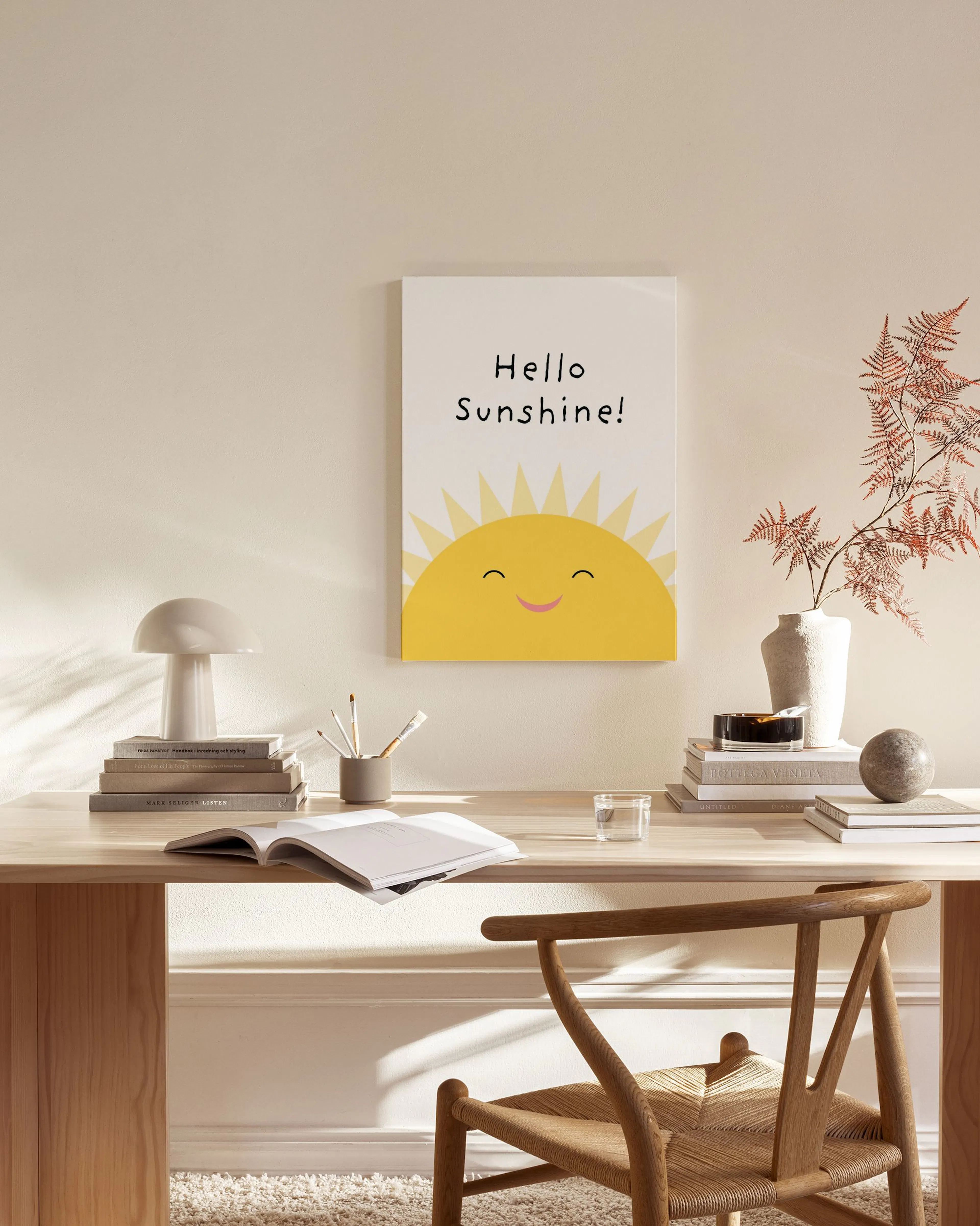 Canvastavla med ett glatt gult solansikte och texten Hello Sunshine! i ett ljust vardagsrum.