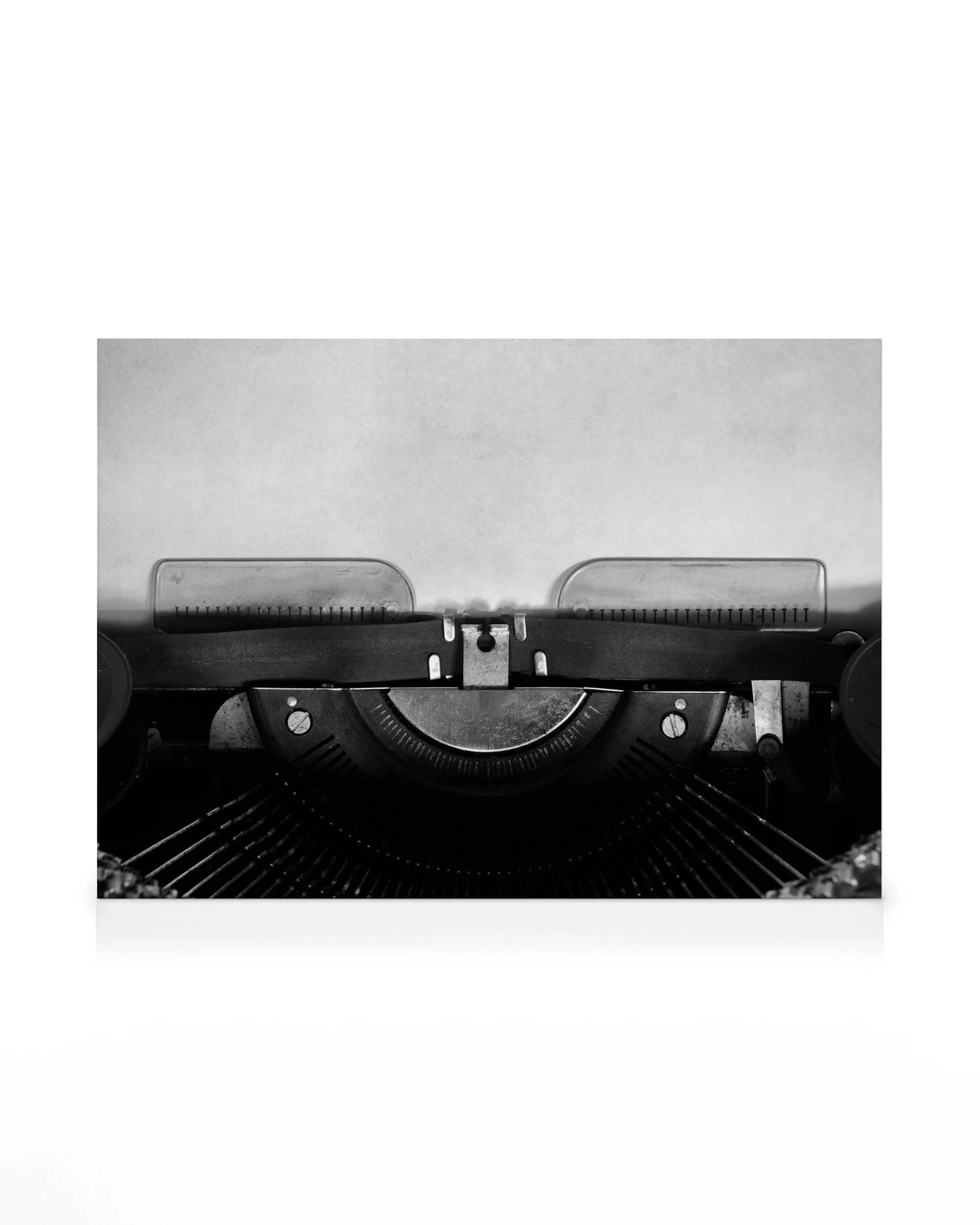 Black and white vintage typewriter with a blank page, ready for a story. Retro writing machine with classic aesthetic.
