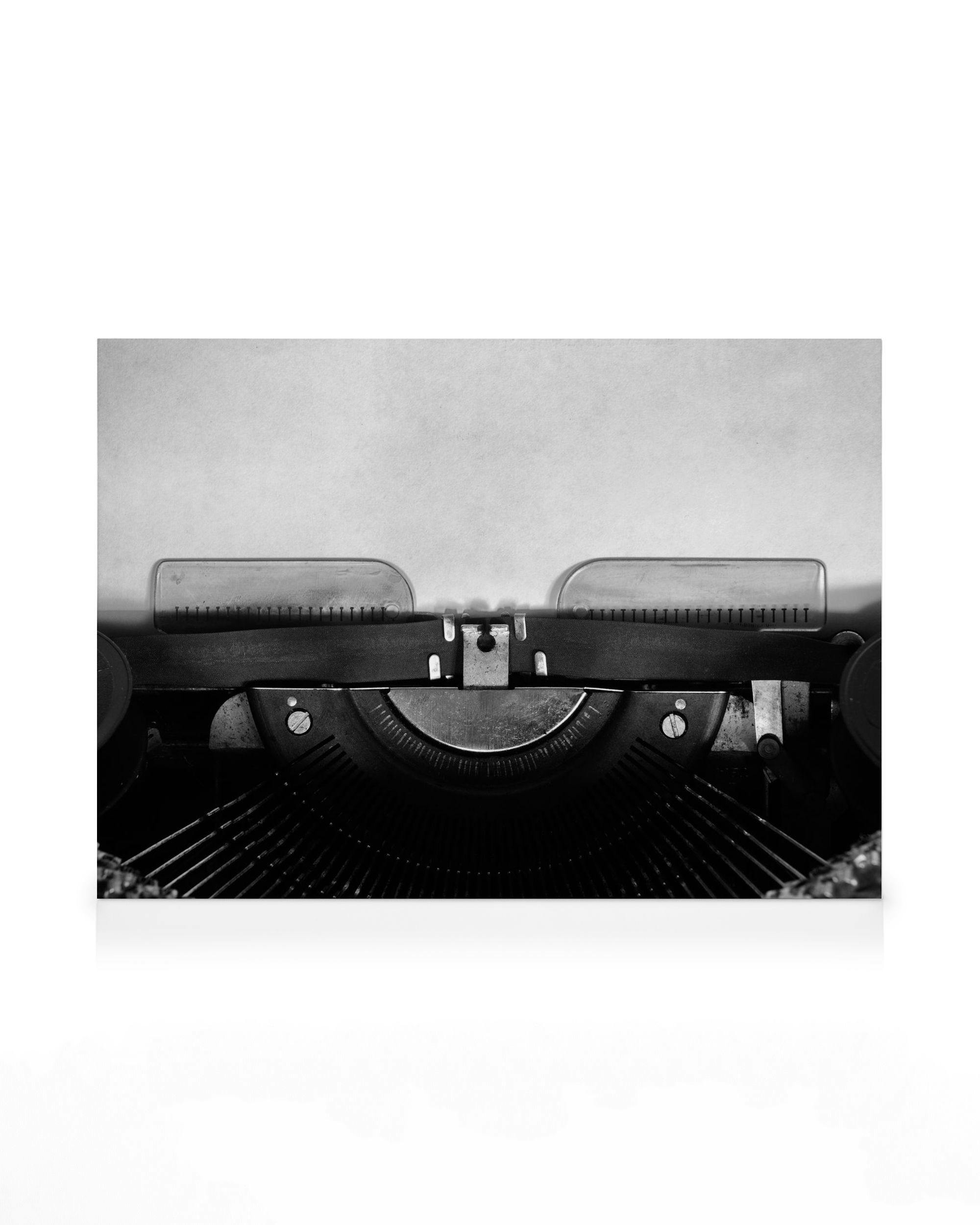 Leinwand mit Schwarz-Weiß-Foto einer Vintage-Schreibmaschine, die ein leeres Blatt Papier enthält, bereit zum Beschreiben.