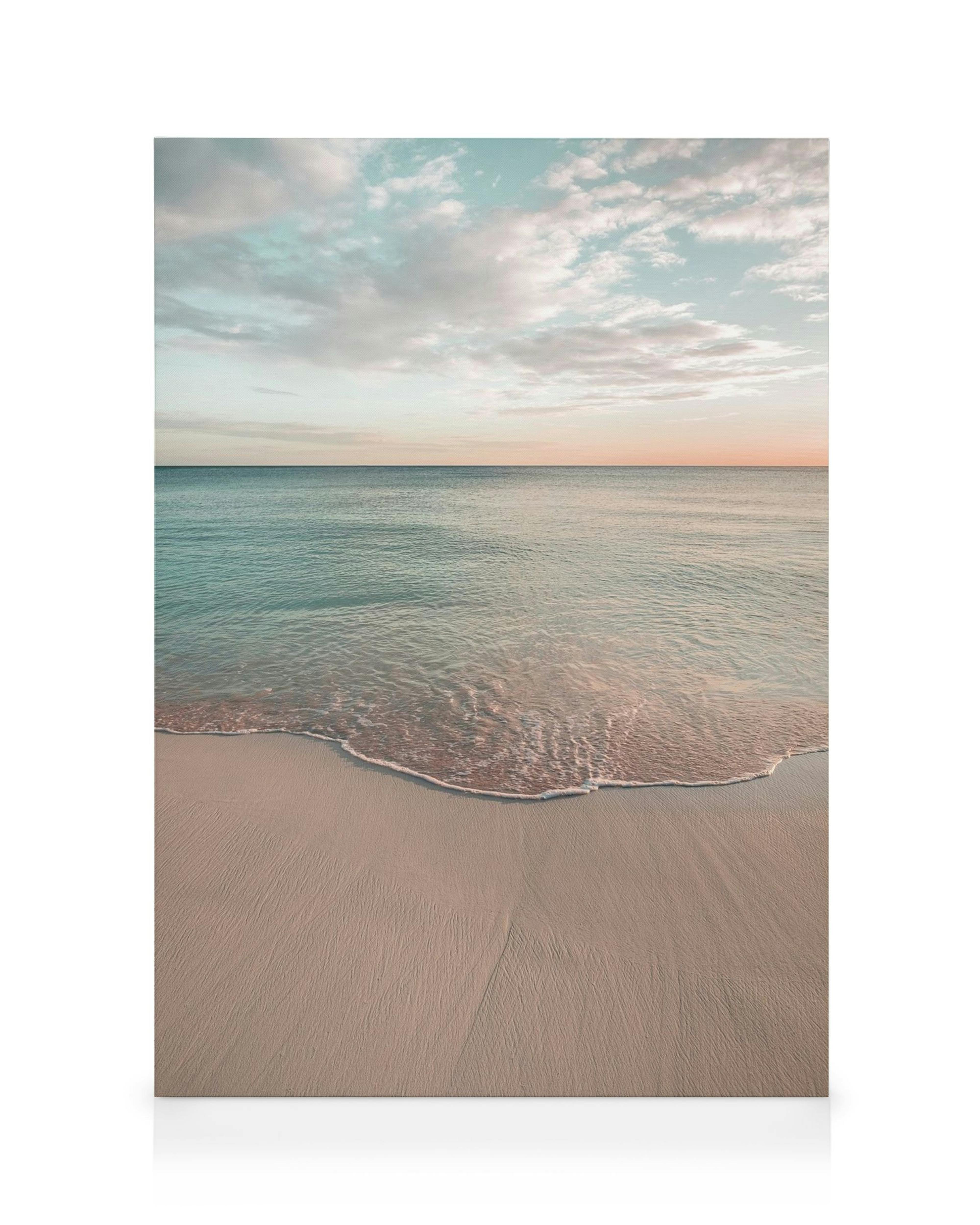 Lienzo de playa tranquila al amanecer, con arena suave, agua azul y cielo rosado/azul, nubes.