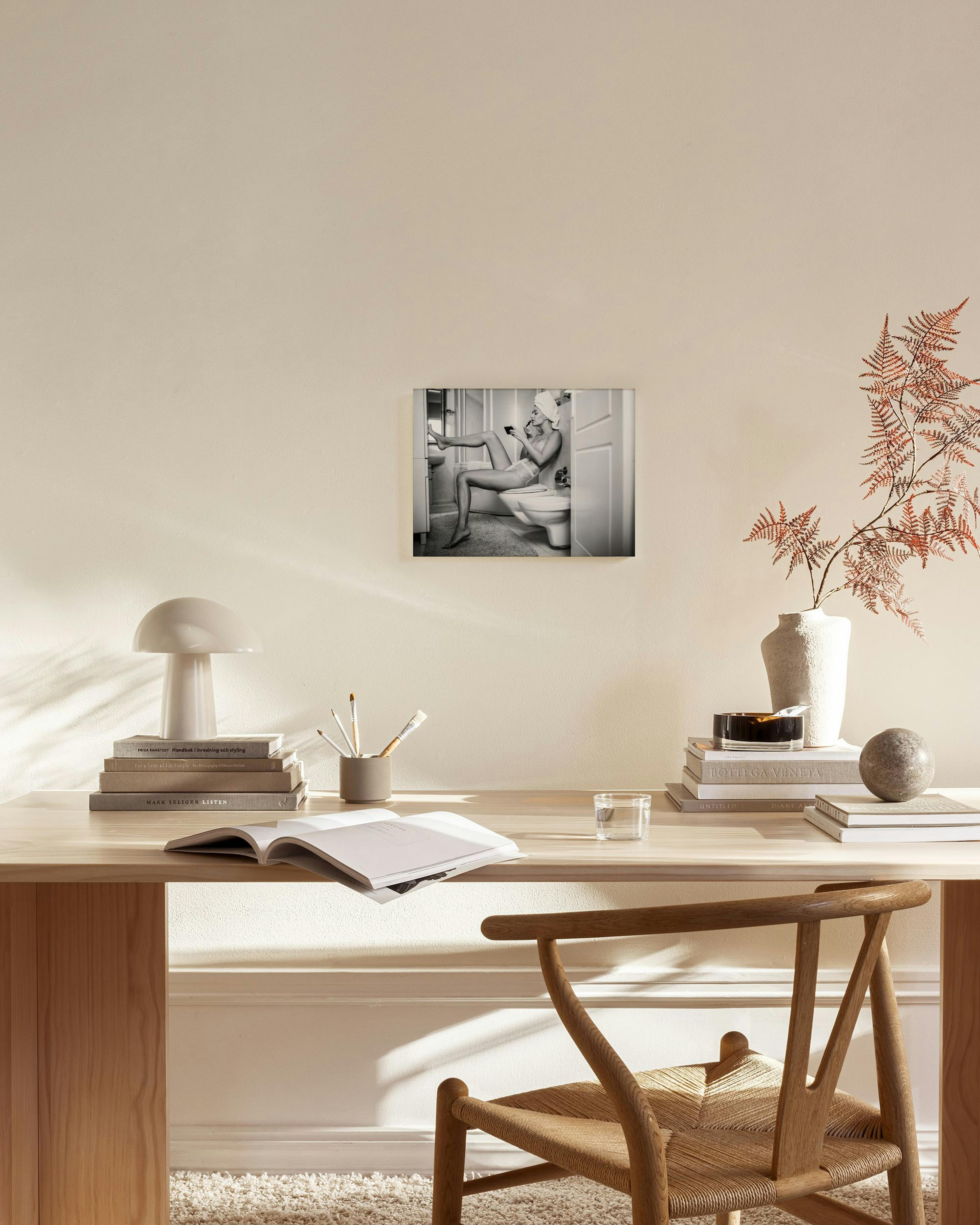 Schwarz-weiß Leinwandbild einer Frau mit Handtuch auf dem Kopf, die auf einer Toilette sitzt und sich schminkt. Hängt über einem