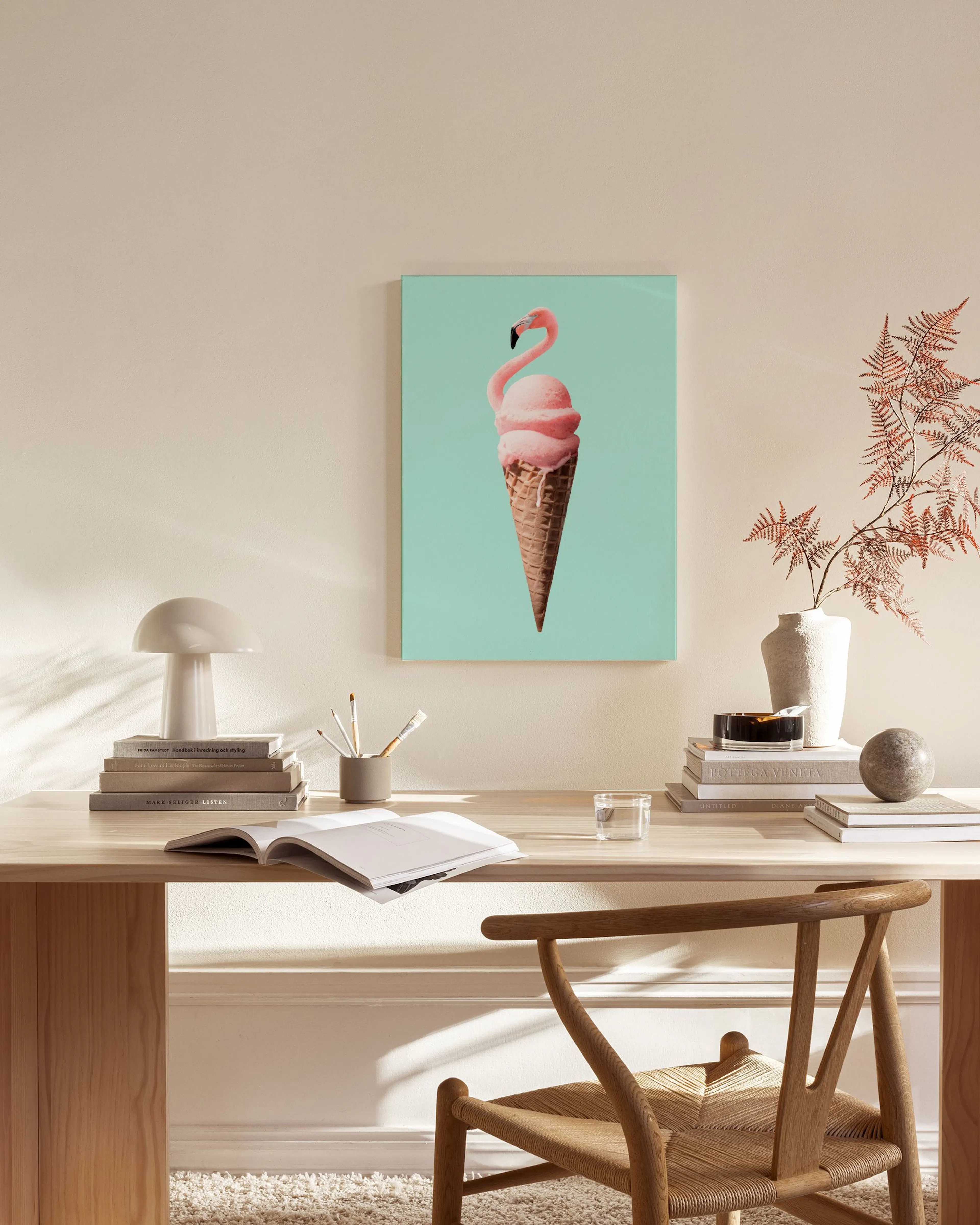 Leinwandbild mit rosa Flamingo-Eis in Waffeltüte auf mintgrünem Hintergrund, hängt in einem modernen Wohnzimmer.