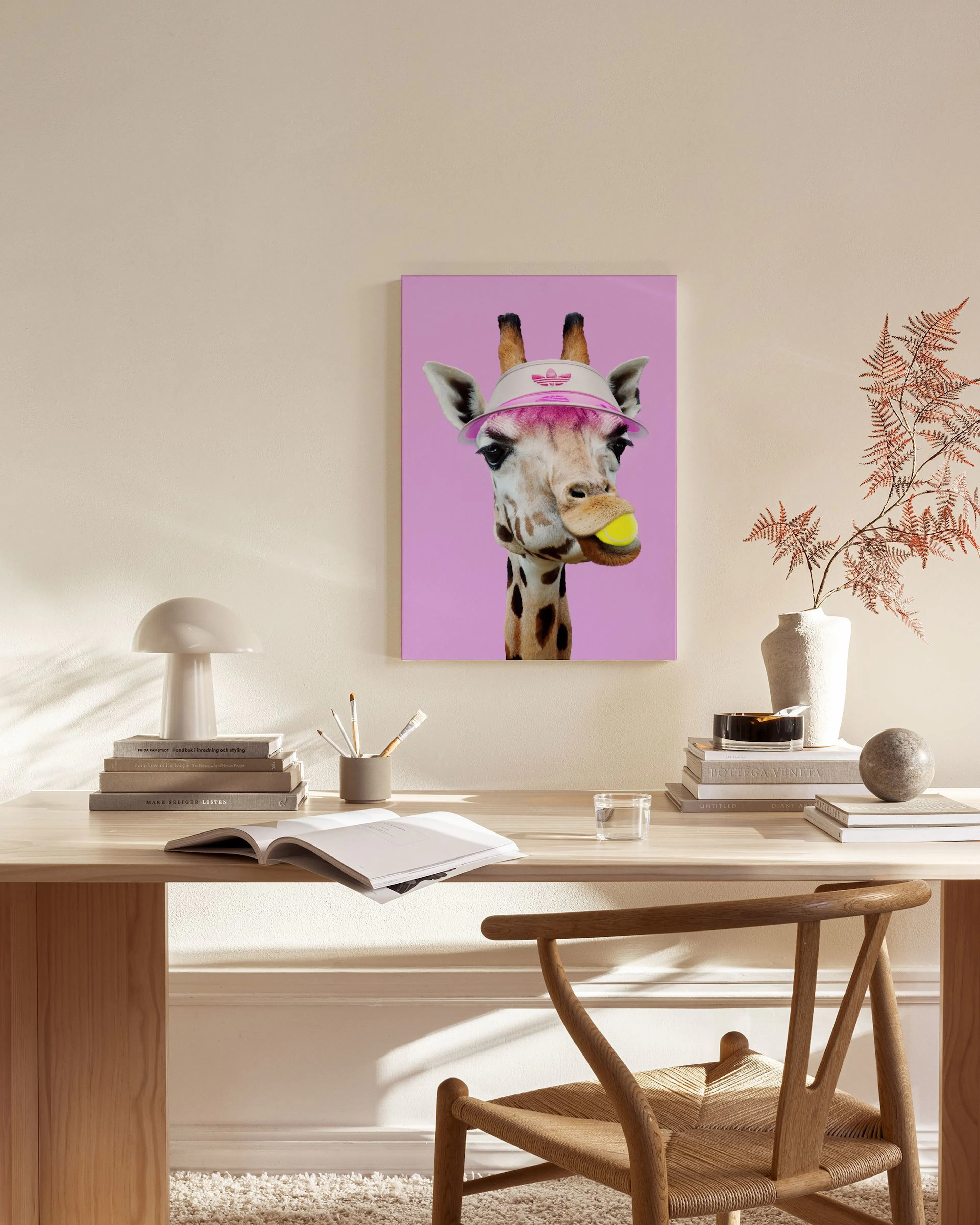 Funky giraffe wearing a pink visor and chewing a tennis ball, displayed in a modern living room.