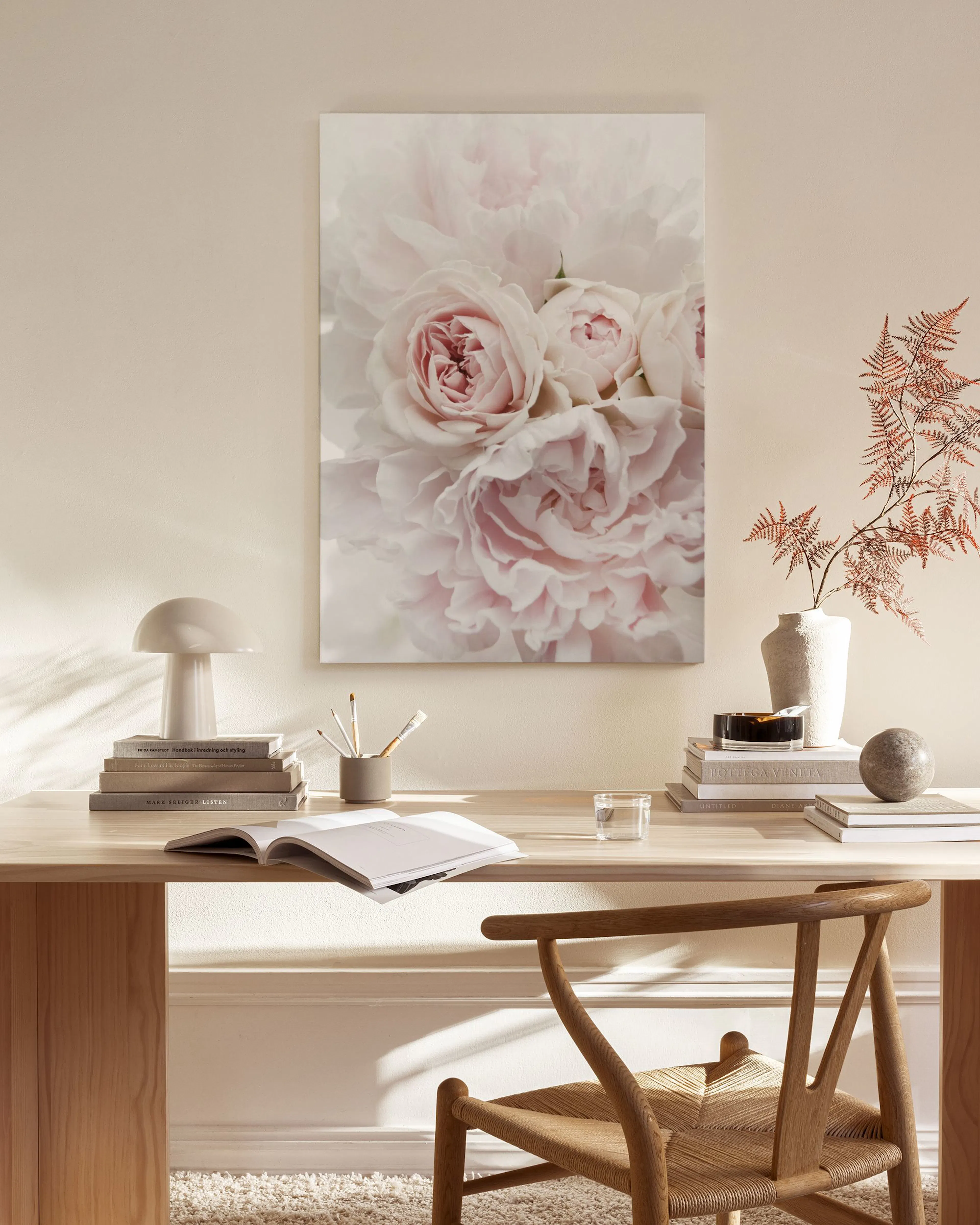Canvas met een close-up van zachtroze rozen en pioenrozen in een lichte woonkamer.