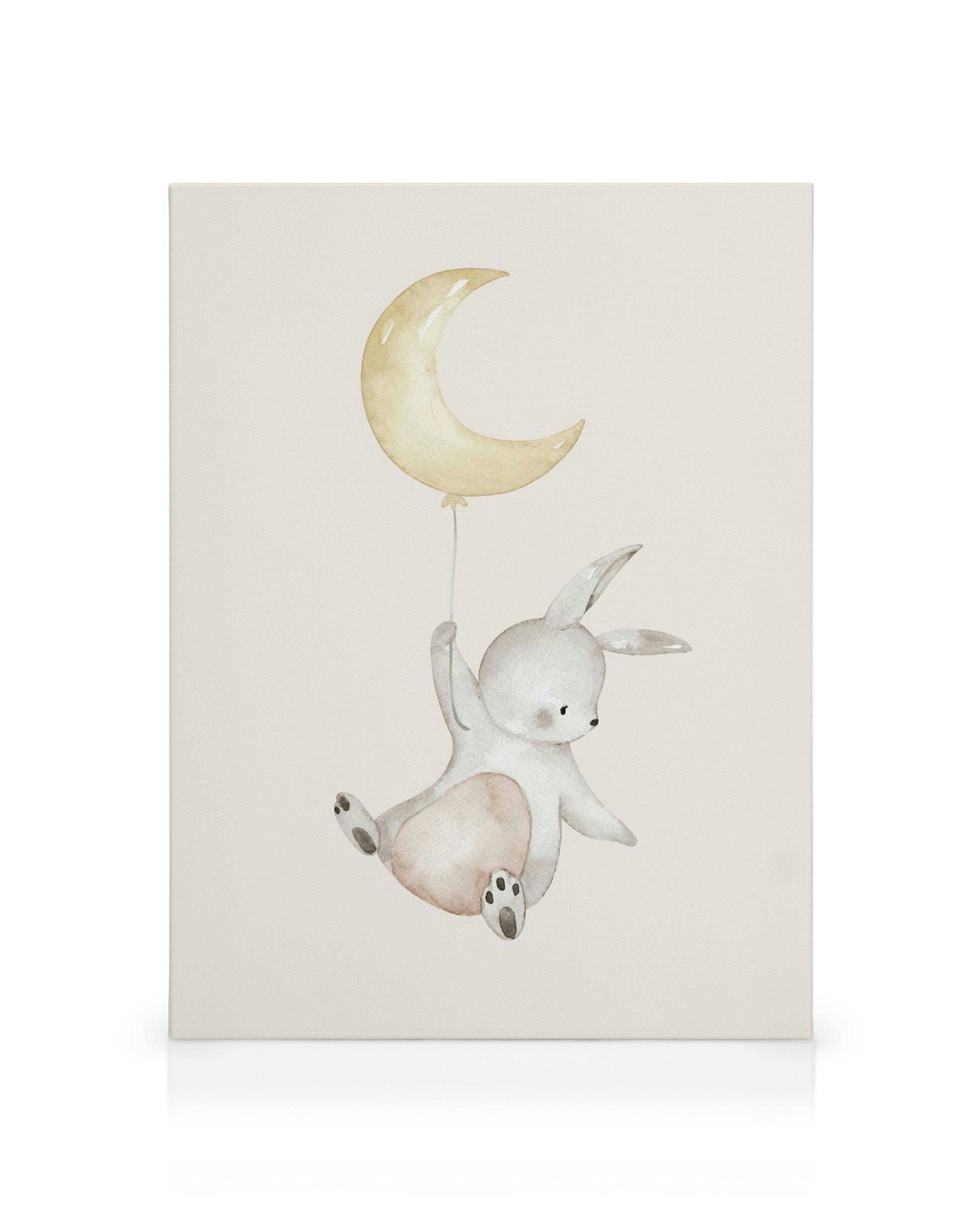 Lienzo infantil con un conejo gris colgando de un globo en forma de luna creciente, sobre un fondo rosa claro.
