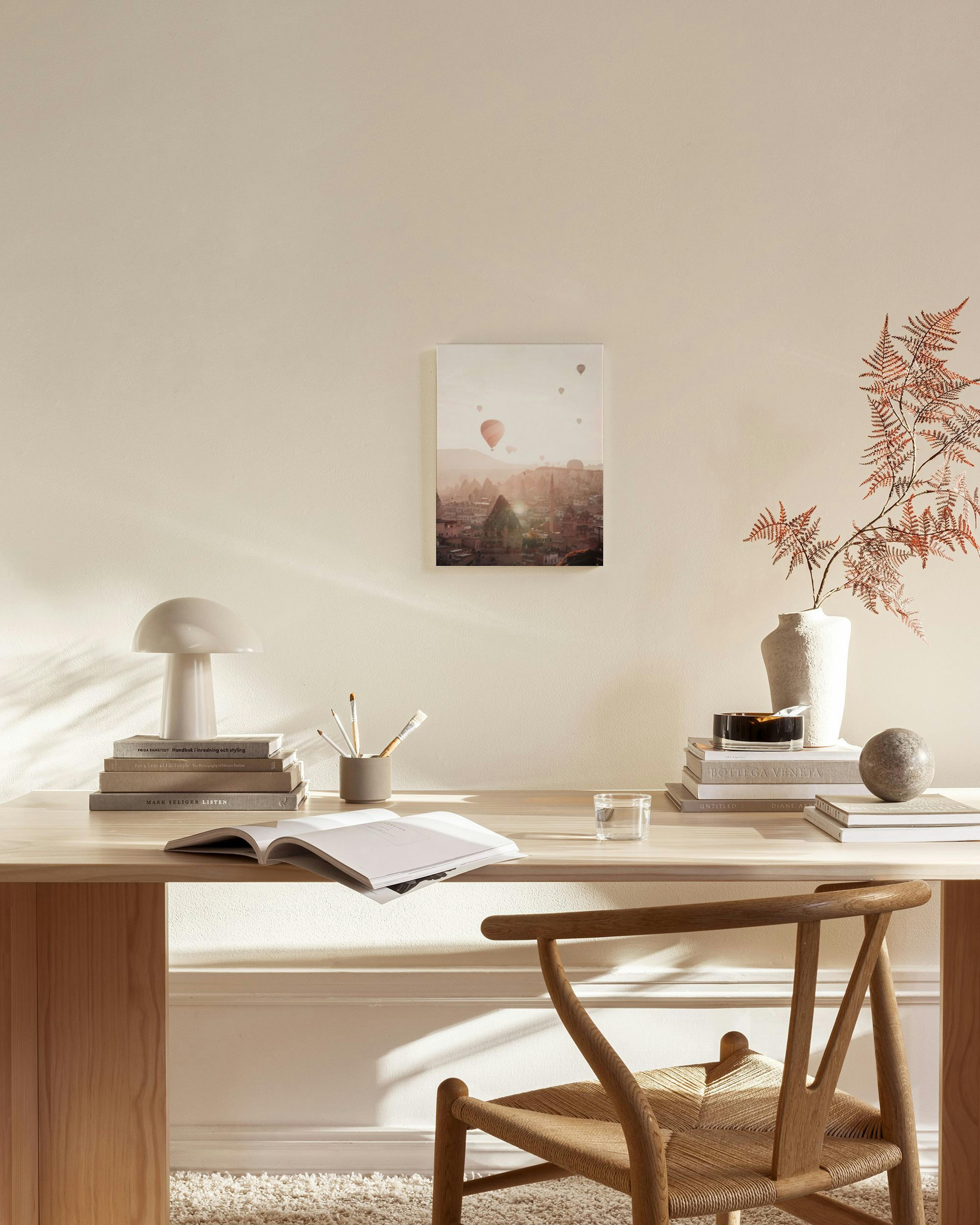 Leinwandbild mit Heißluftballons über einer Stadtlandschaft in warmem Licht, aufgehängt in einem hellen Wohnzimmer über einem Si