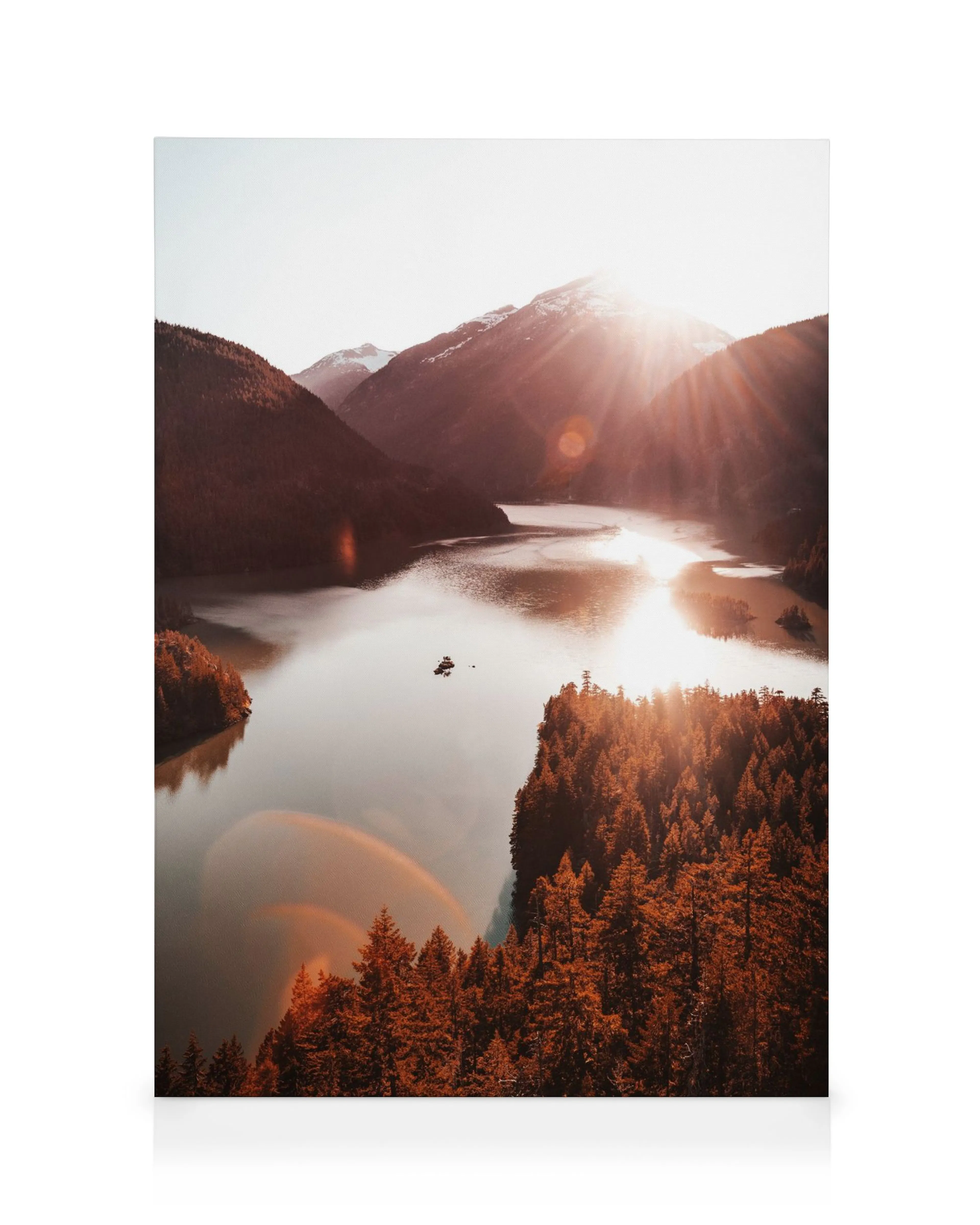 Canvas met bergmeer, oranje bossen, zonsondergang lensflare en bootje