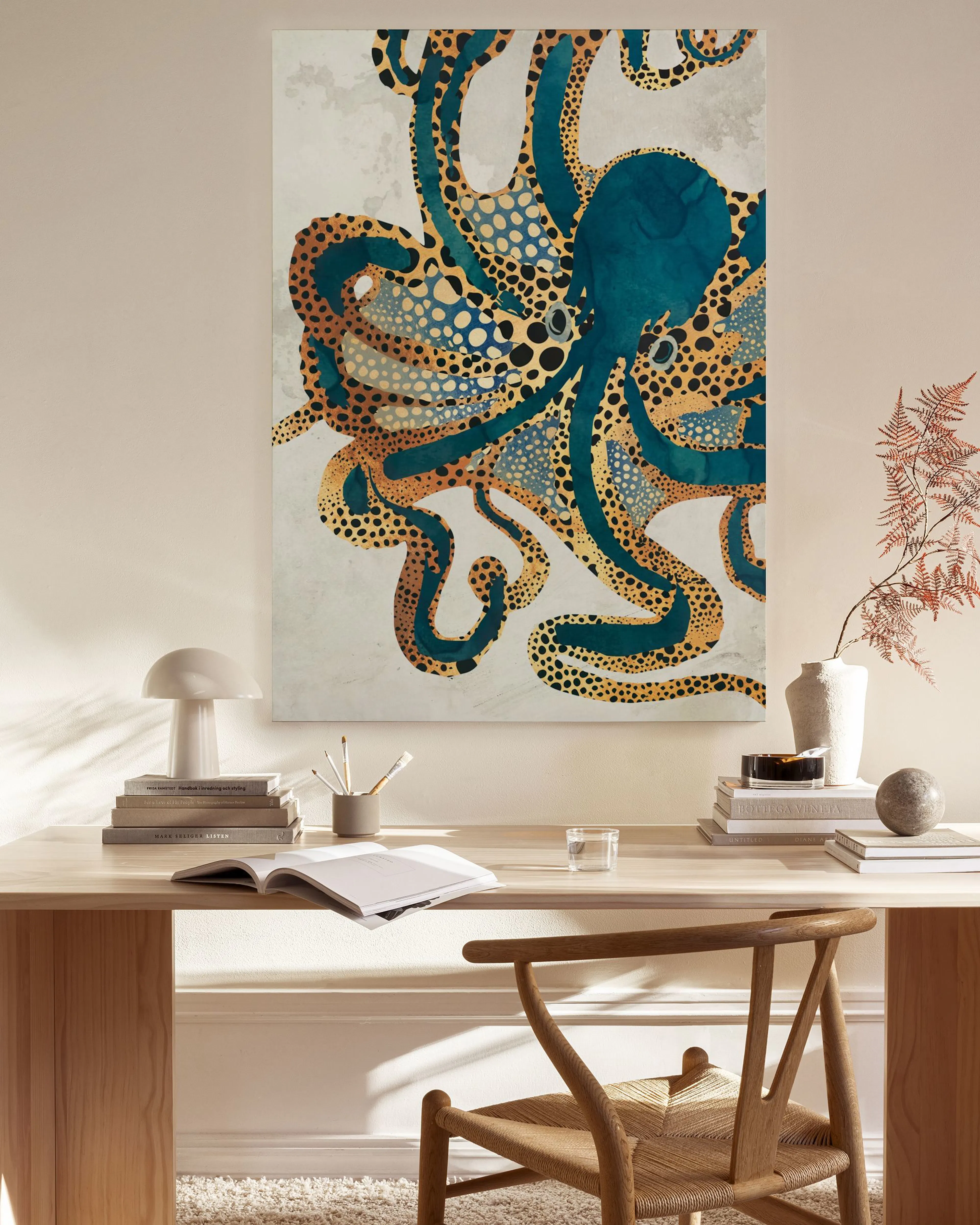 Blue and gold patterned octopus canvas print hanging in a modern living room above a wooden console.