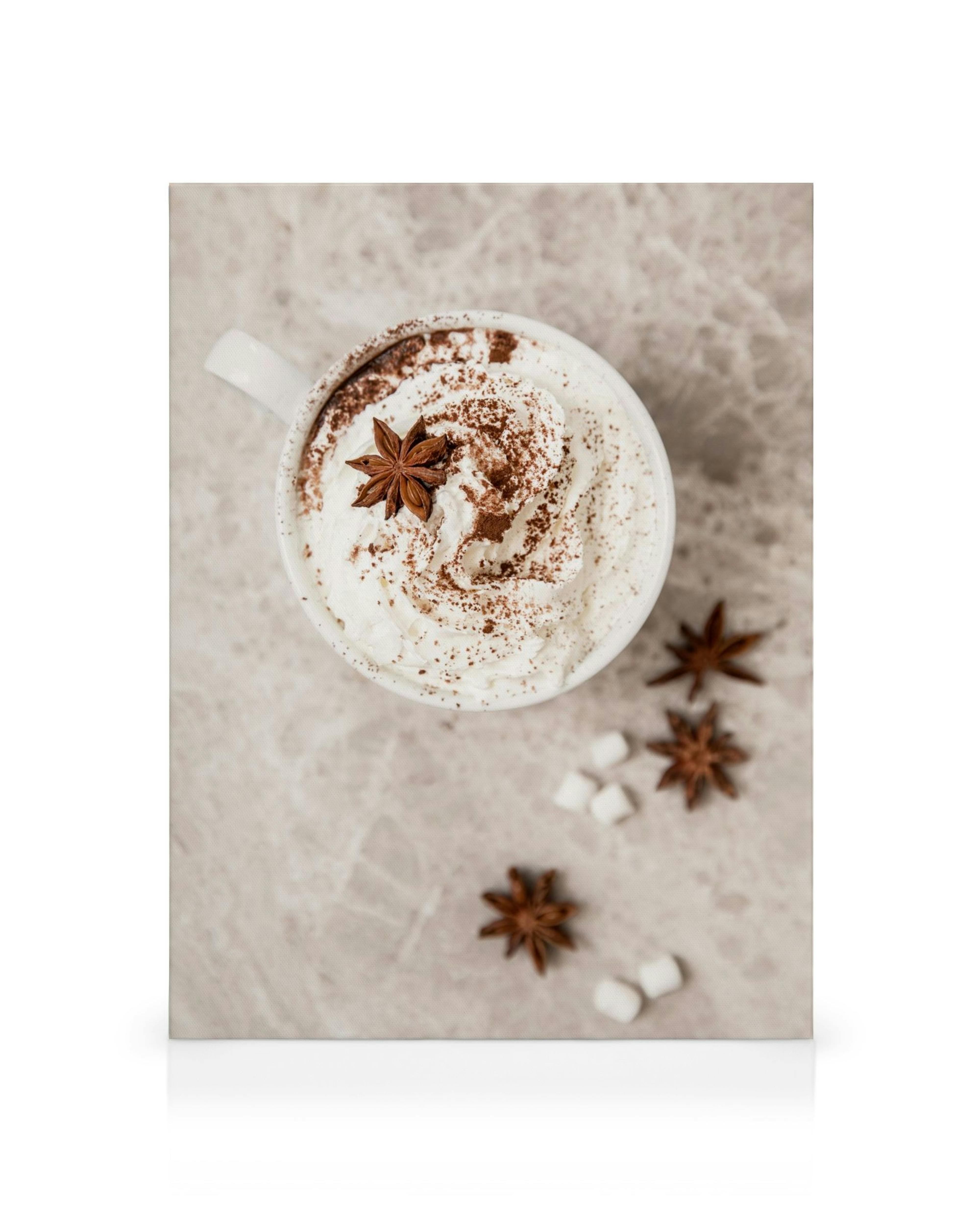 Hot chocolate canvas print with whipped cream, cocoa powder, star anise, and marshmallows on a grey background.