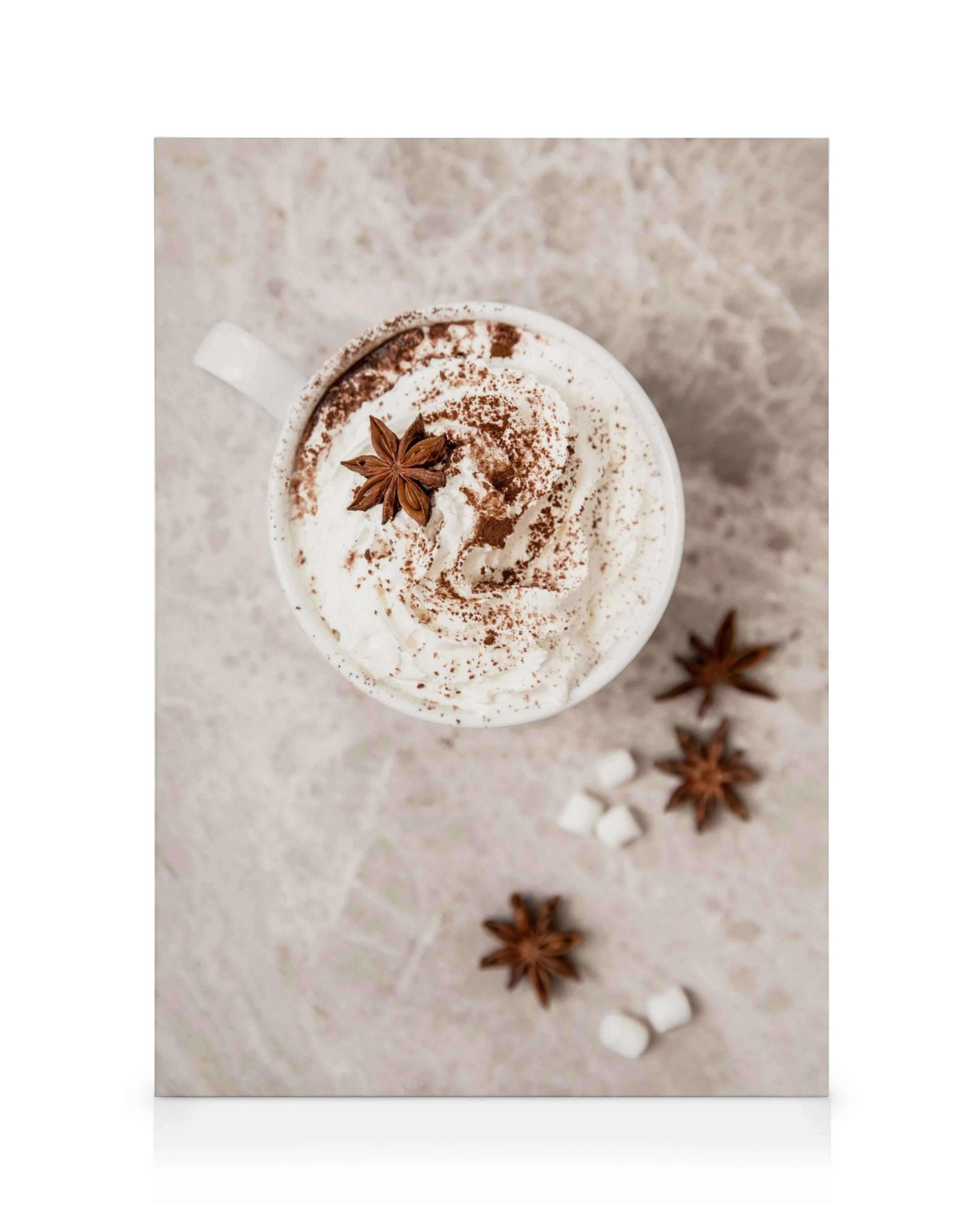 Canvas met warme chocolademelk, slagroom, cacaopoeder, steranijs en marshmallows op een grijze achtergrond.