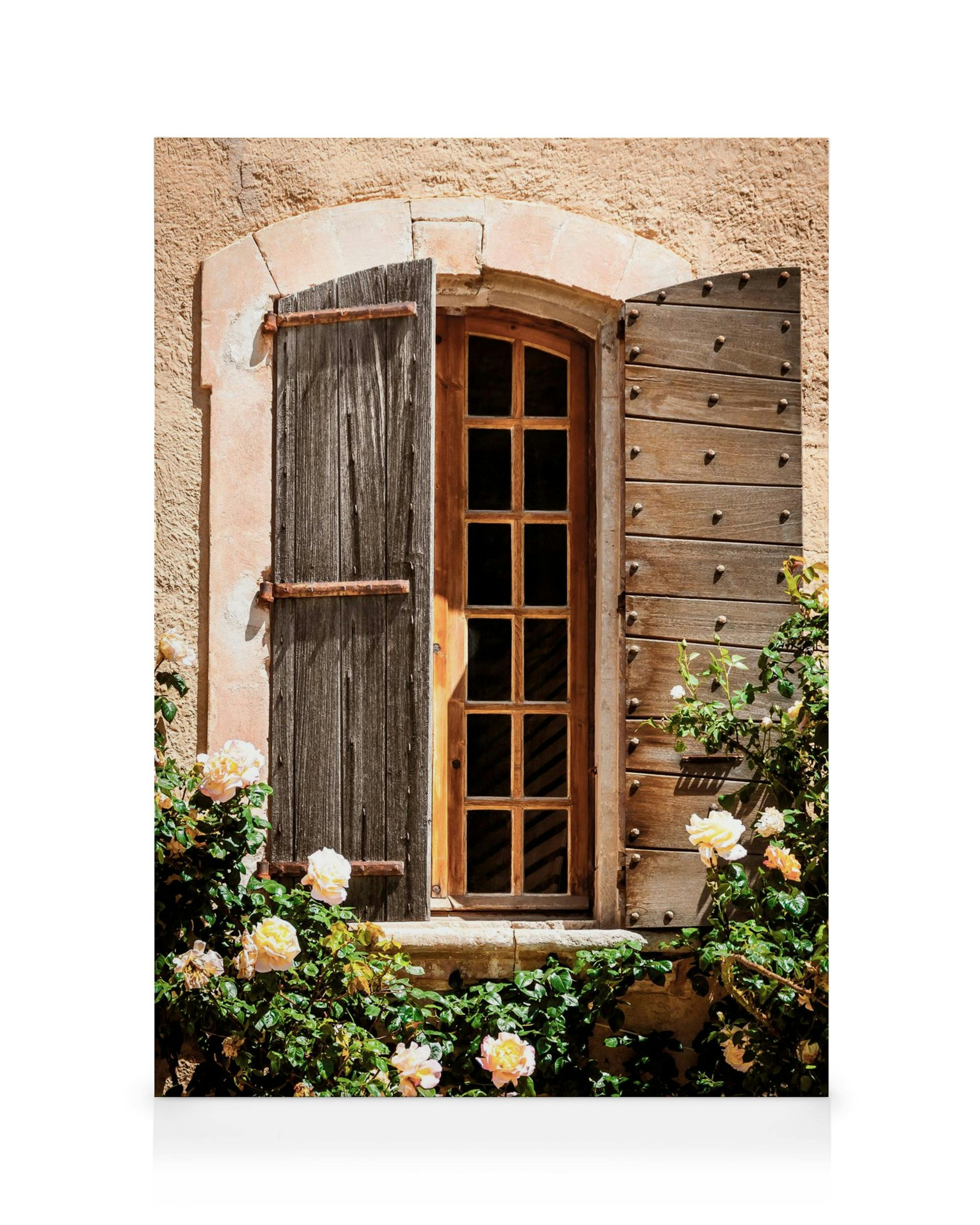 Toile dune fenêtre rustique avec volets en bois ouverts, entourée de roses crème et de feuillage vert.