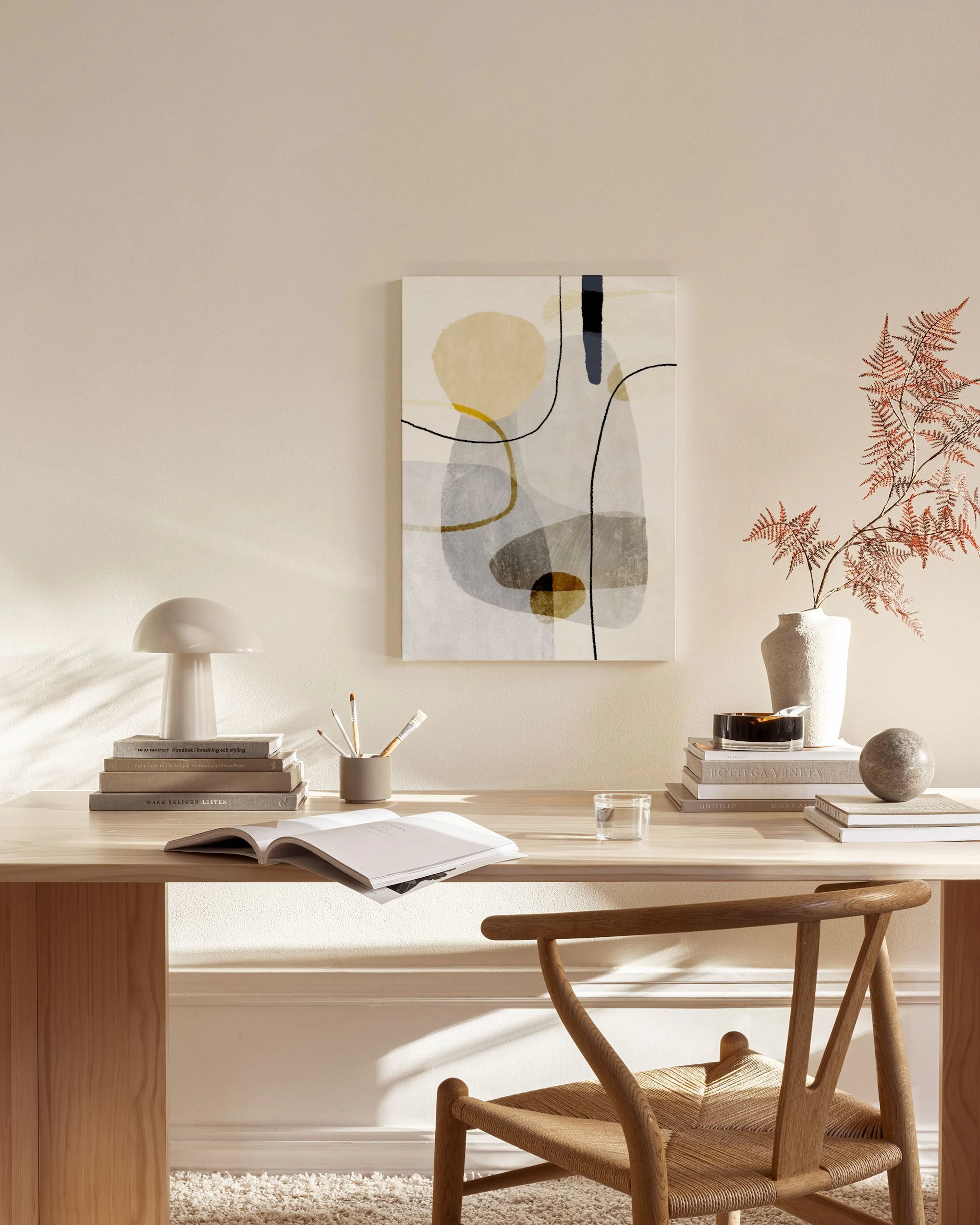Toile abstraite aux formes jaune, grises et noires, avec des lignes fines, accrochée au mur dun salon lumineux.