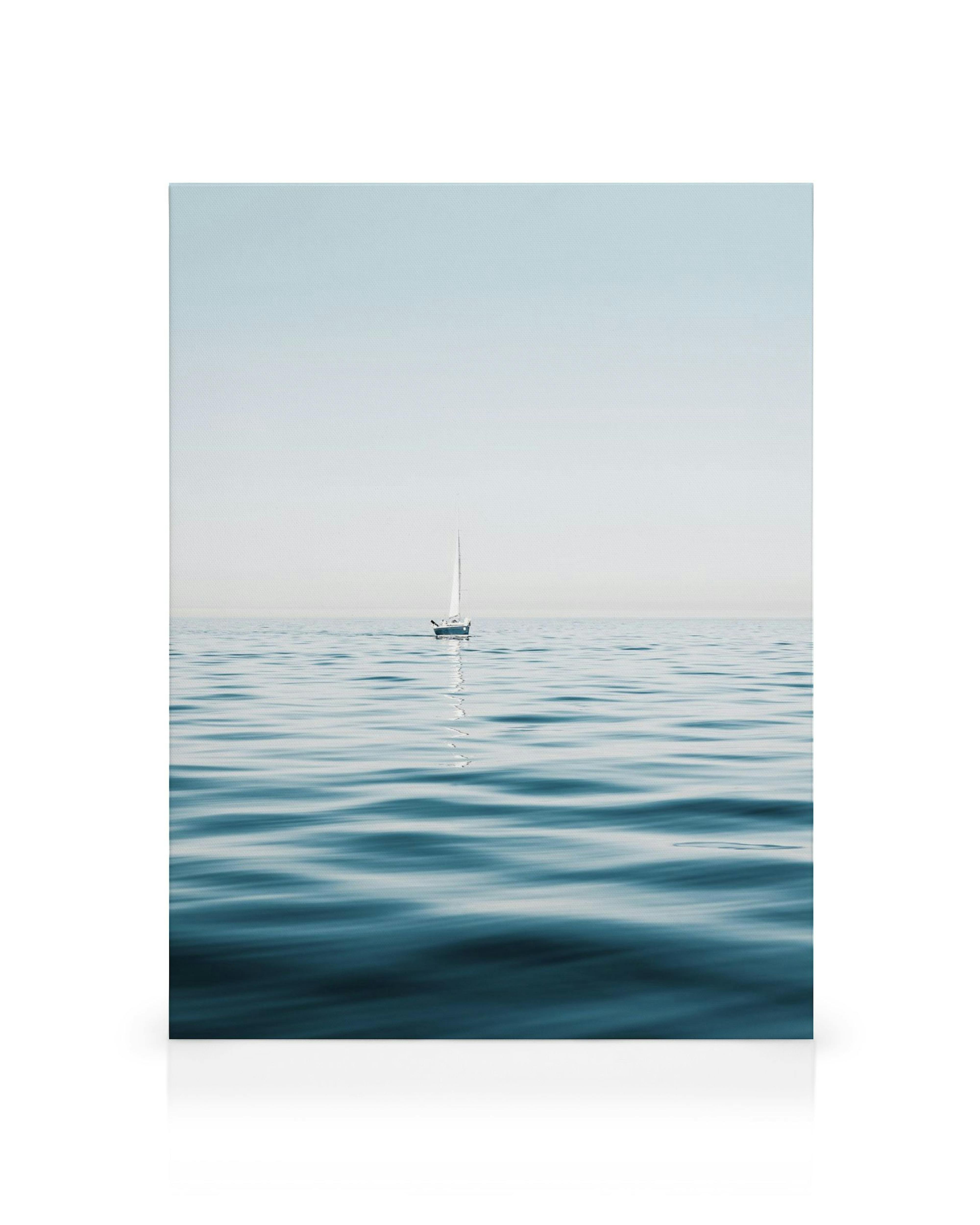 White sailboat on calm blue ocean with a clear sky, minimalist nautical canvas art.