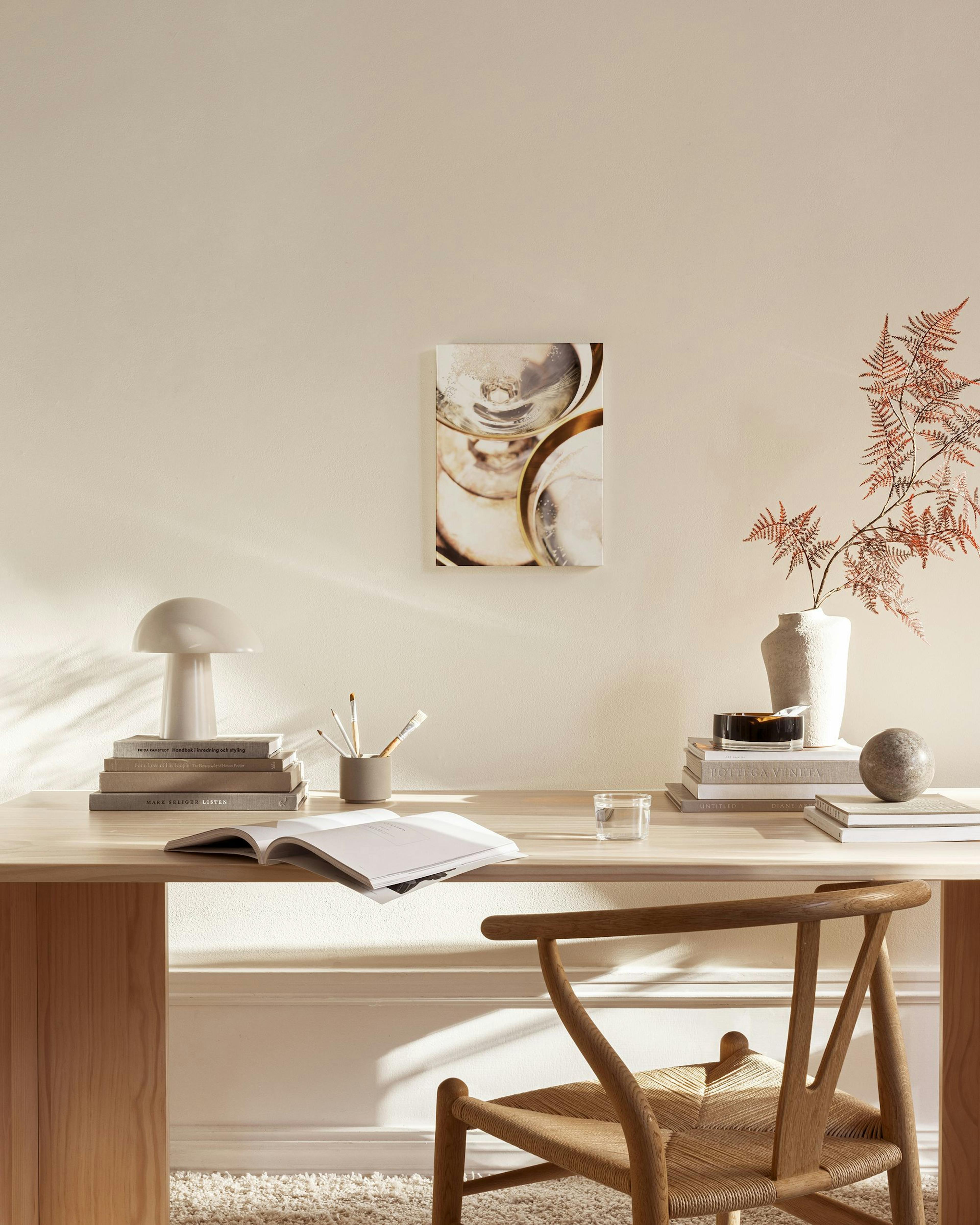 A canvas print of champagne glasses with bubbles, hanging in a neutral-toned living room above a wooden console.