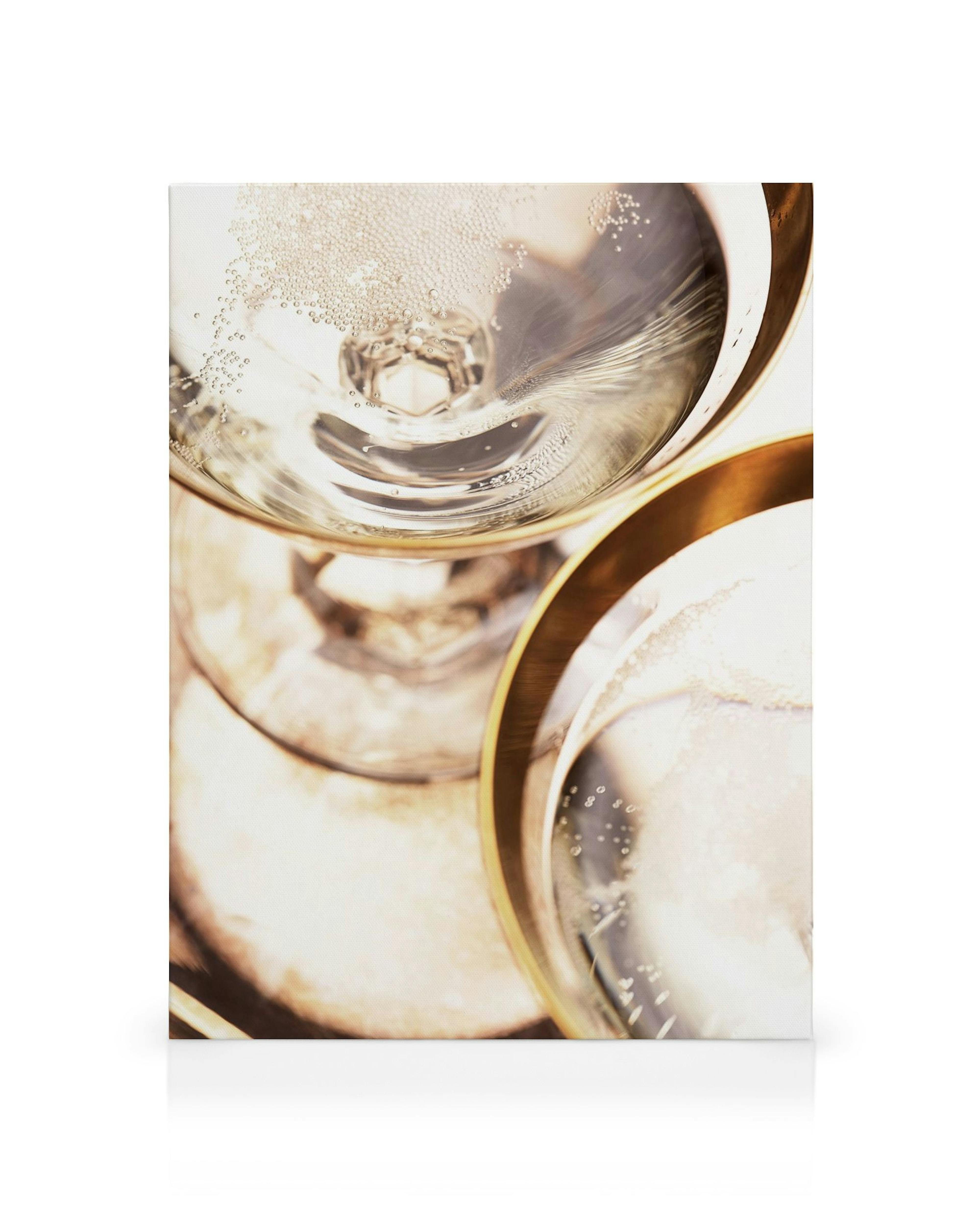 Close-up view of two champagne glasses filled with sparkling bubbly, golden liquid, and reflections.