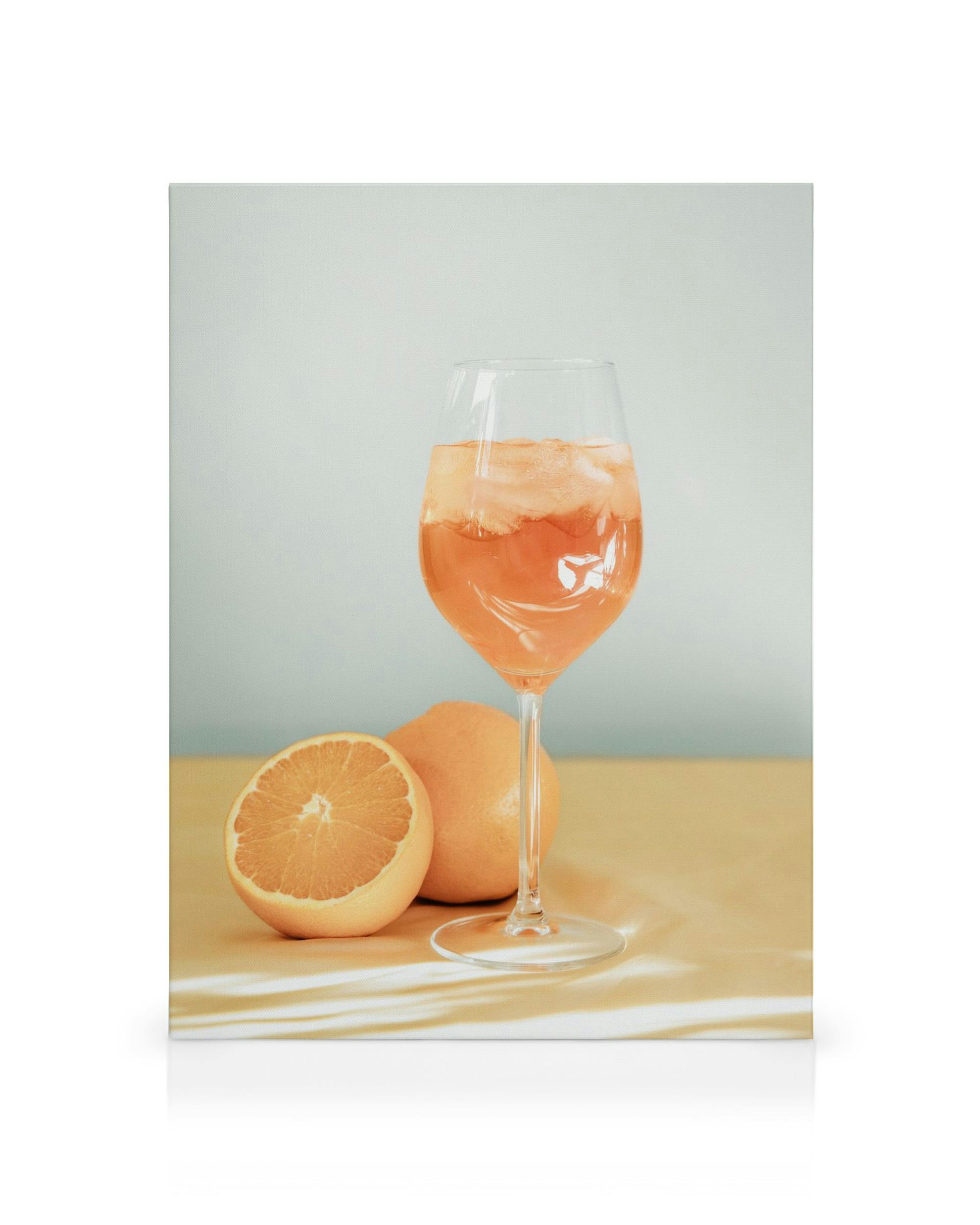 Toile avec verre de cocktail rose et tranches dorange, parfait pour une cuisine ou un bar
