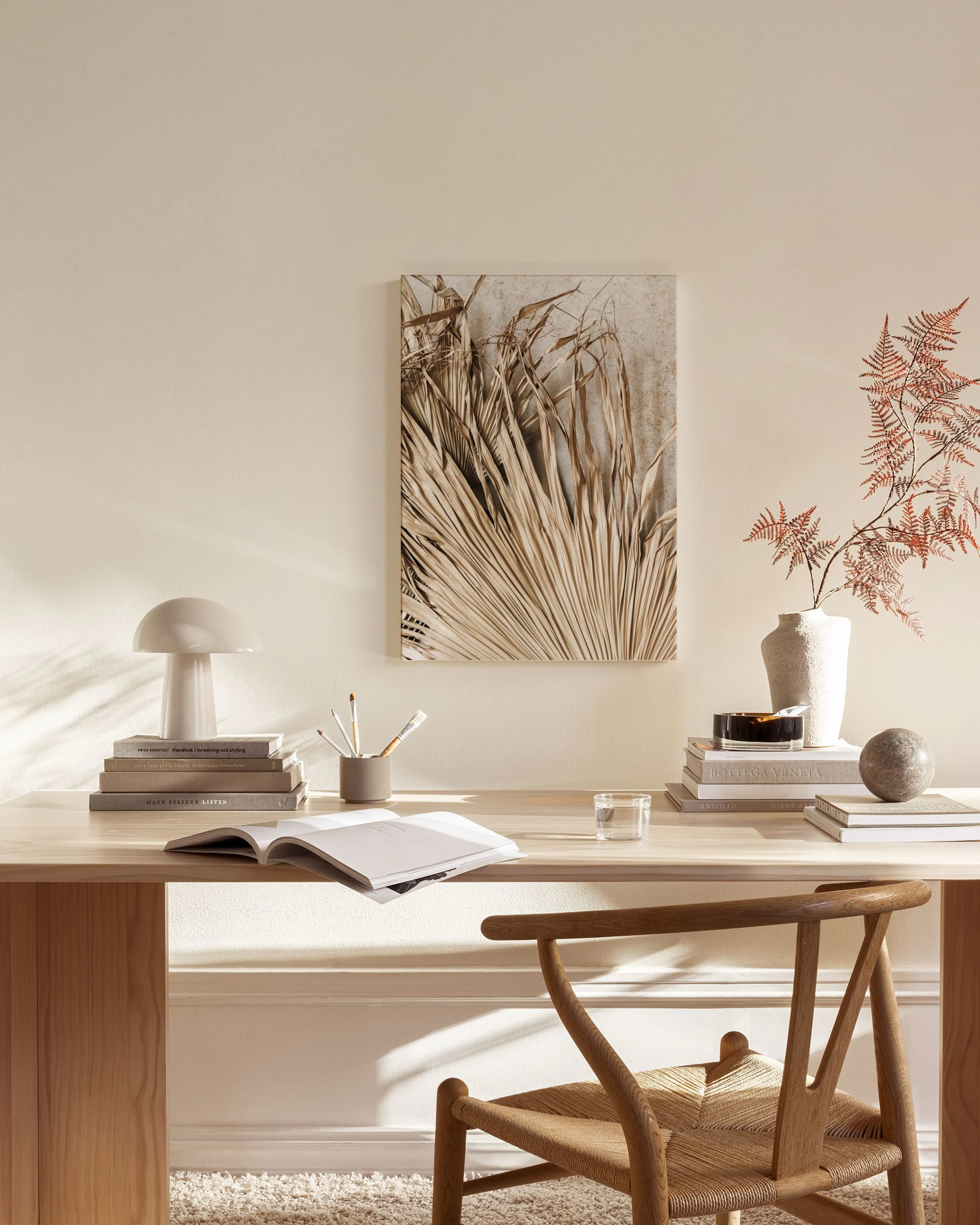 Leinwandbild mit getrockneten Palmblättern in Beige, hängend in einem modernen Wohnzimmer über einem Sideboard.