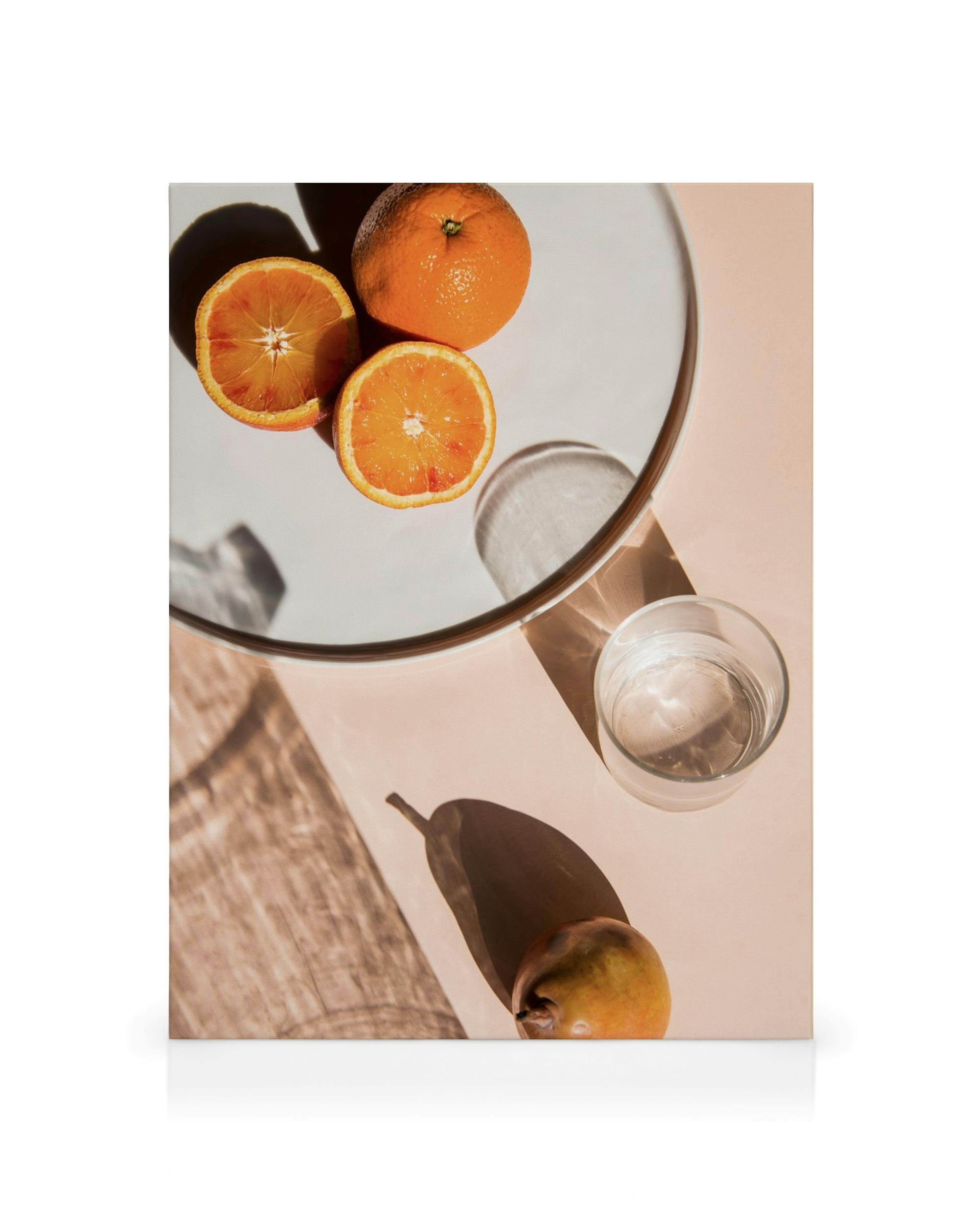Leinwanddruck mit Orangen, Birne und Glas Wasser, helles Licht, Schatten