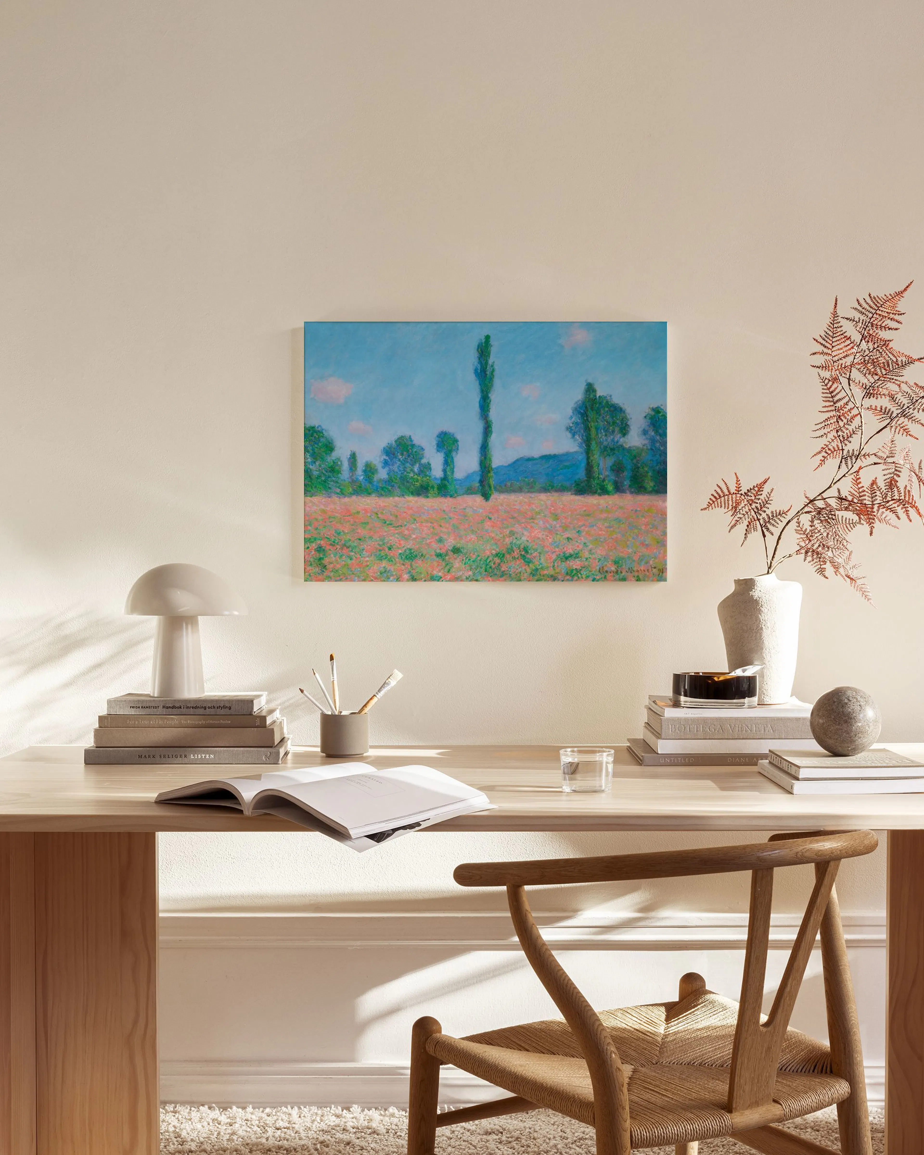 Leinwandbild mit einem Mohnfeld und Bäumen unter blauem Himmel, über einem Sideboard in einem Wohnzimmer.