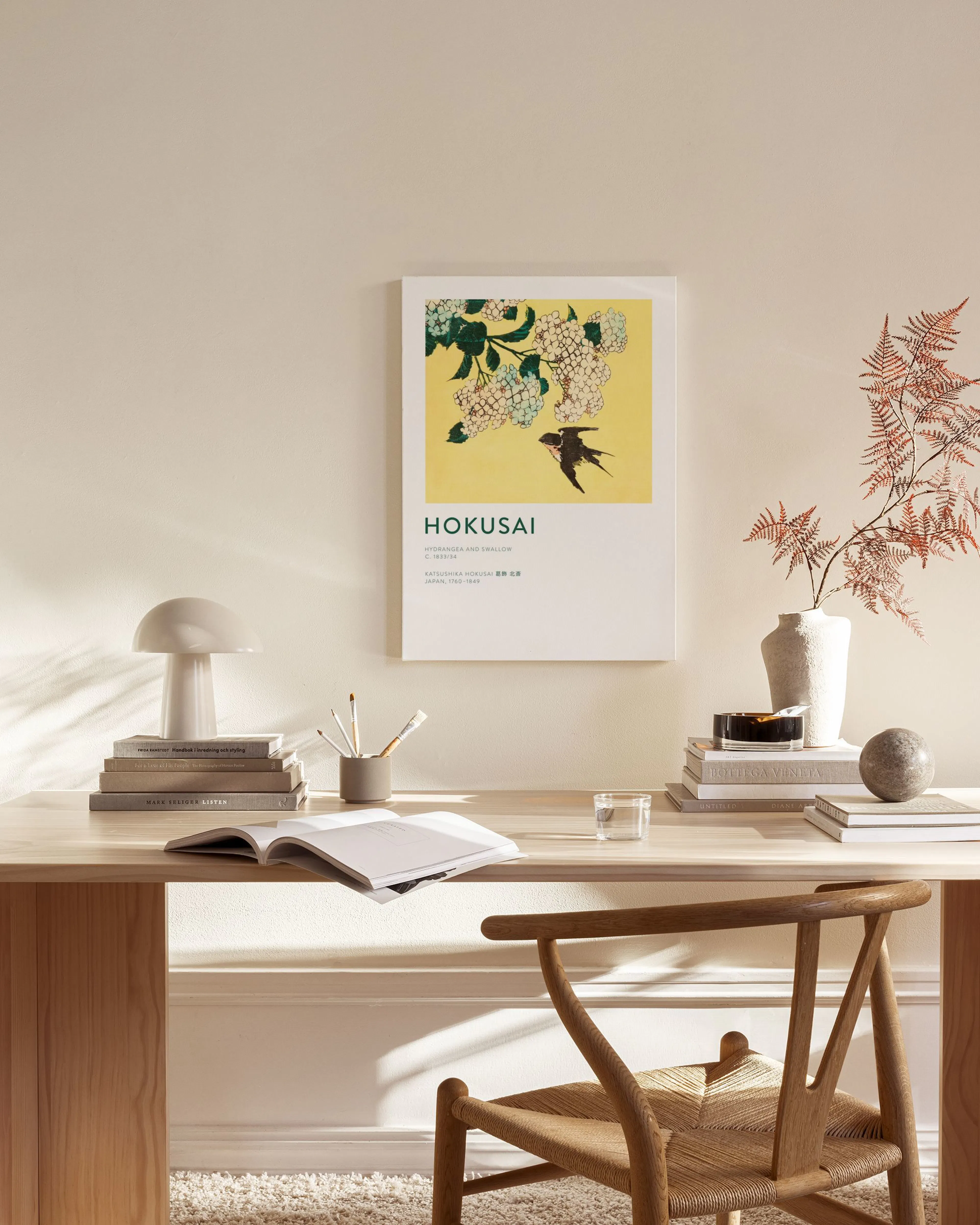 Hokusai print of a swallow and white hydrangeas on a yellow background, displayed in a minimal living room.