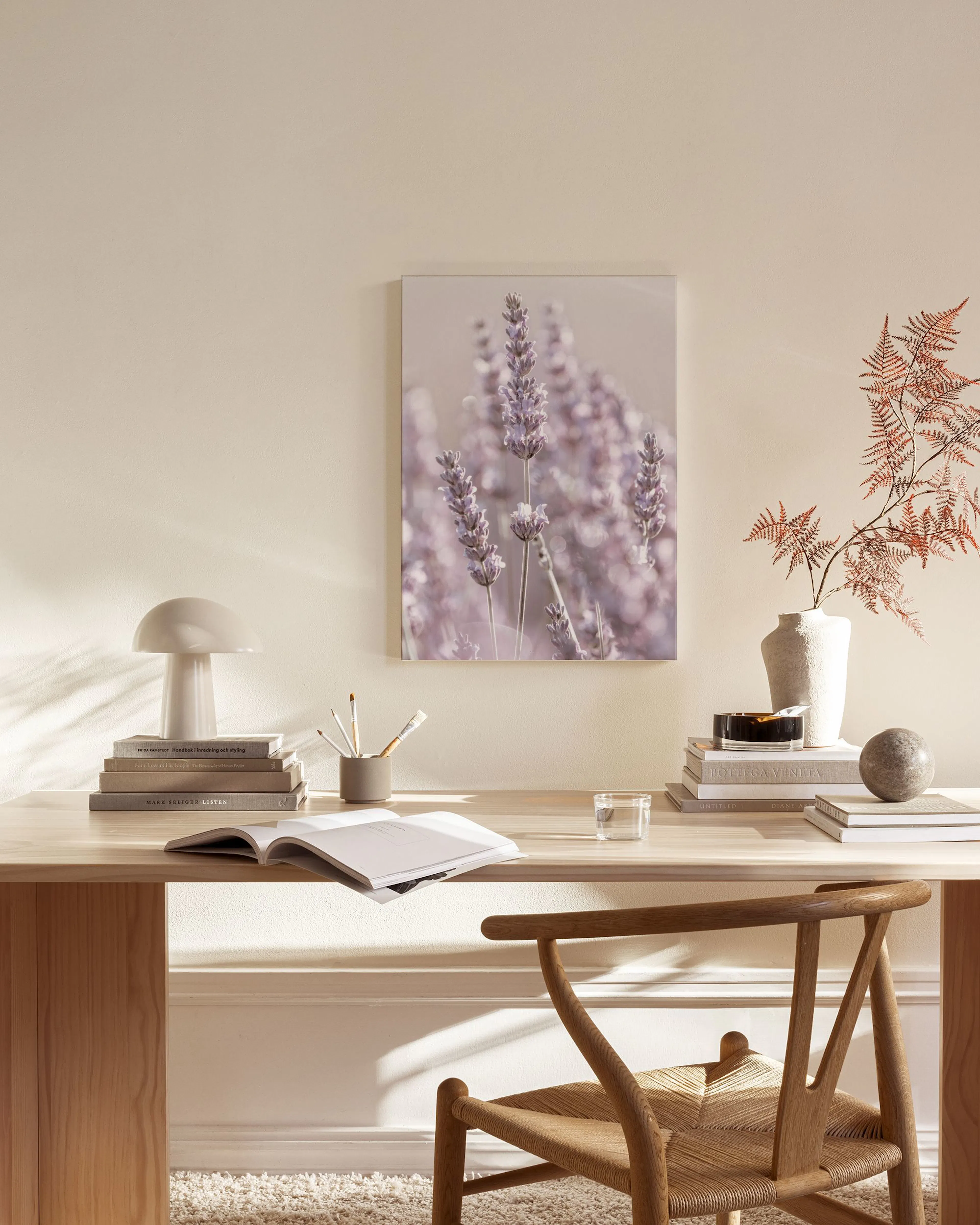 Stampa su tela di lavanda viola appesa in un soggiorno moderno, sopra una mensola in legno.