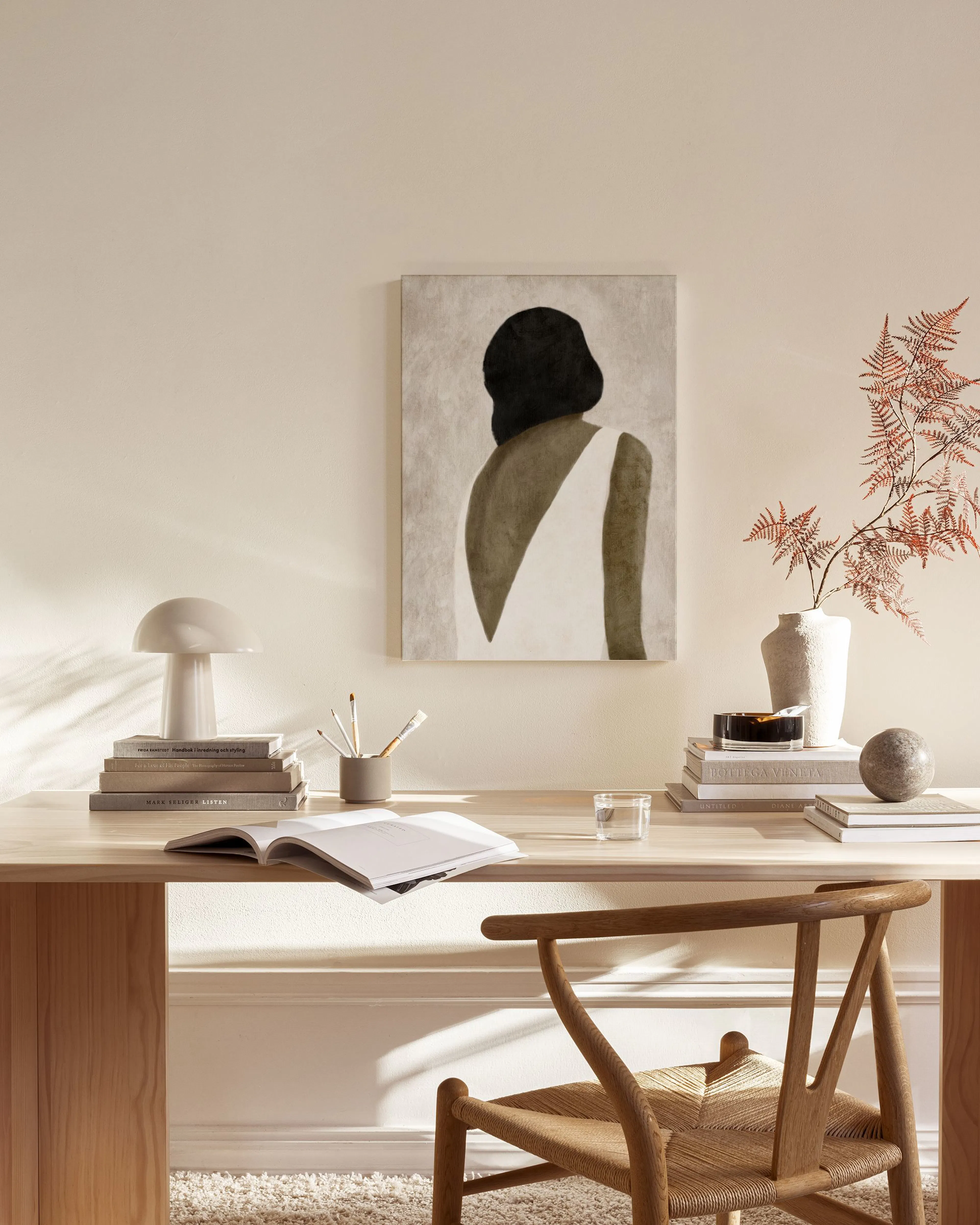Canvas print of a woman with dark hair and a white dress from behind, hanging in a minimalist living room.