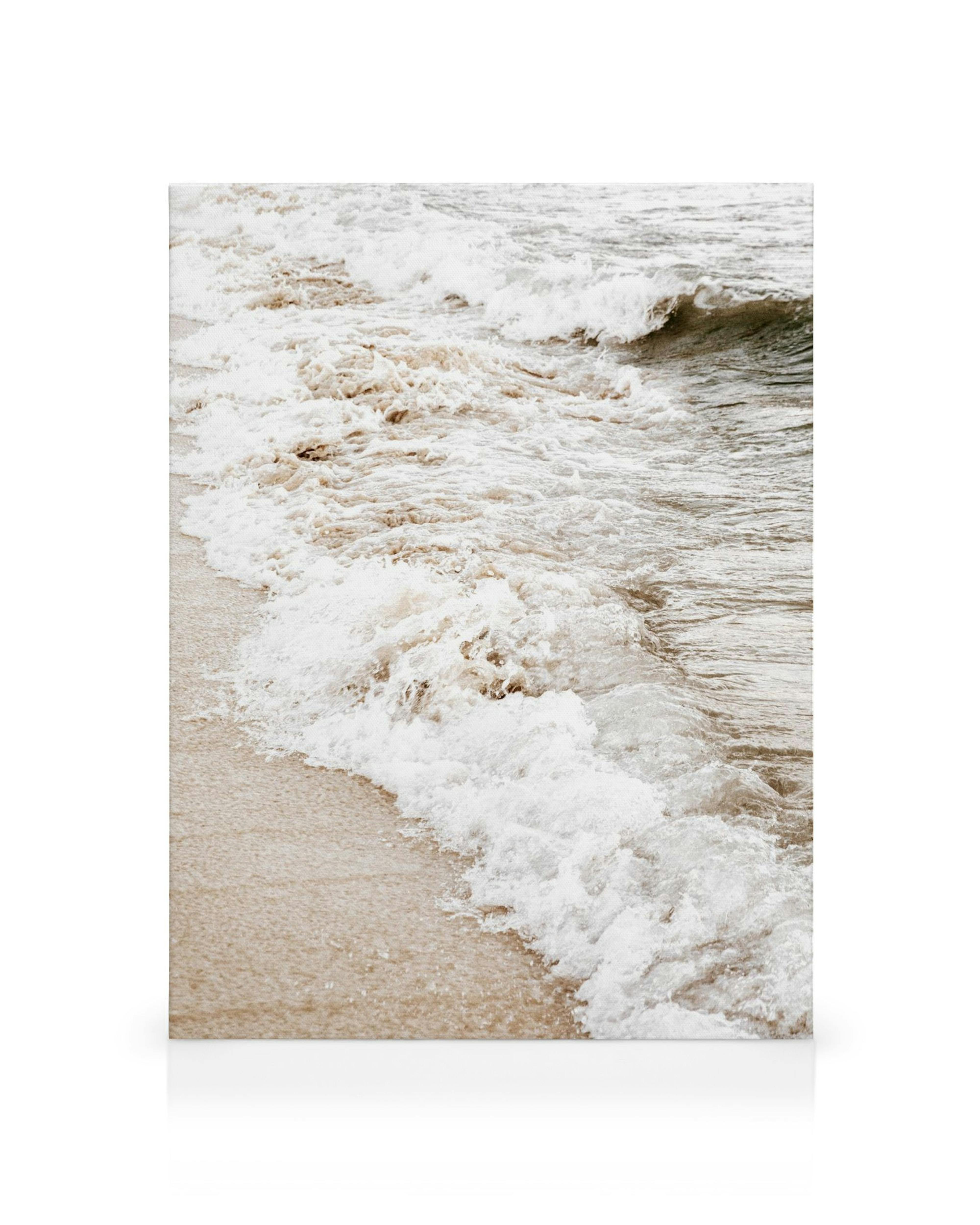 Lienzo de olas rompiendo con espuma blanca sobre arena beige texturizada, agua marrón creando líneas.