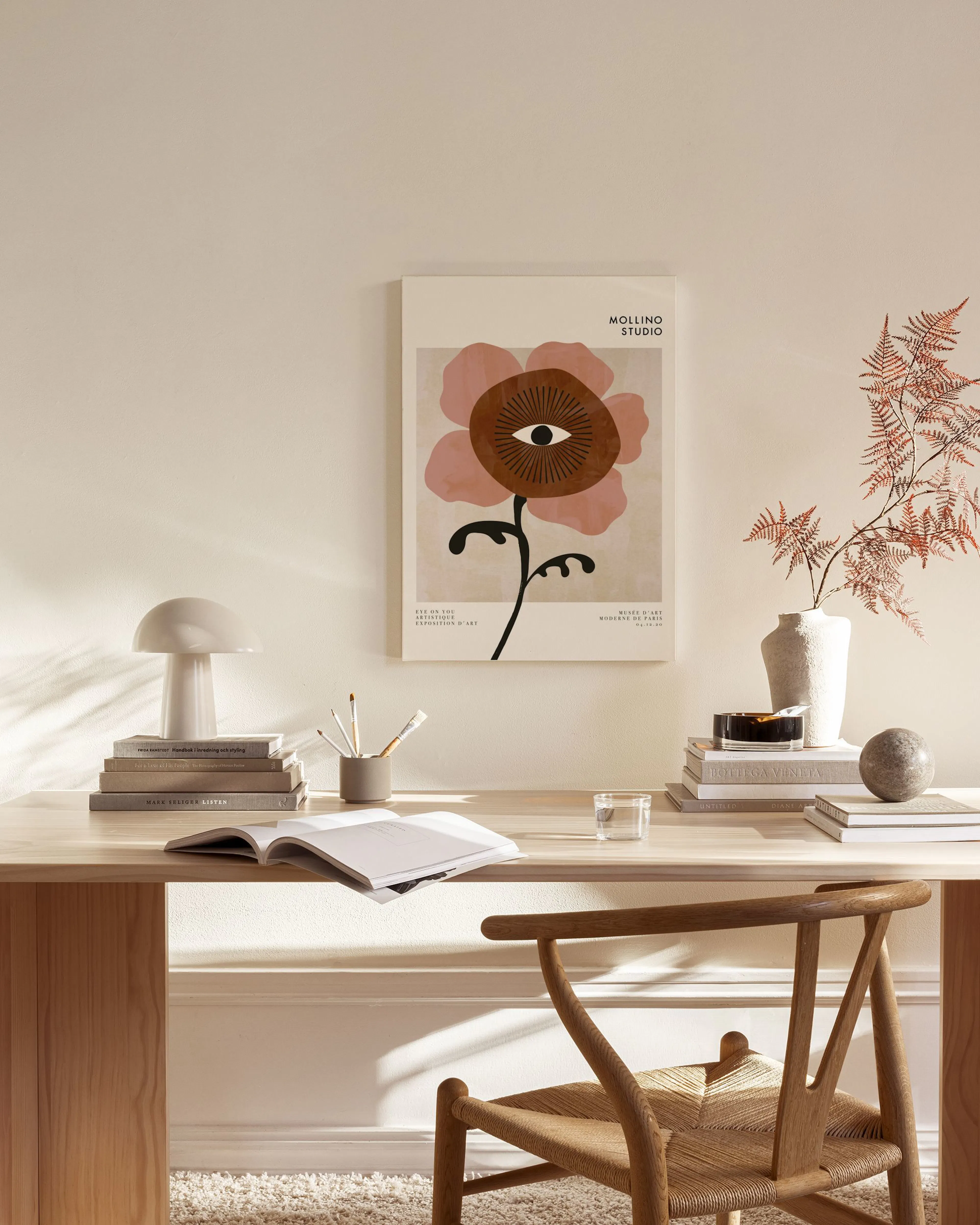 Canvas van een abstracte bloem met bruine en roze tinten, en een oog in het midden, hangend in een moderne woonkamer.