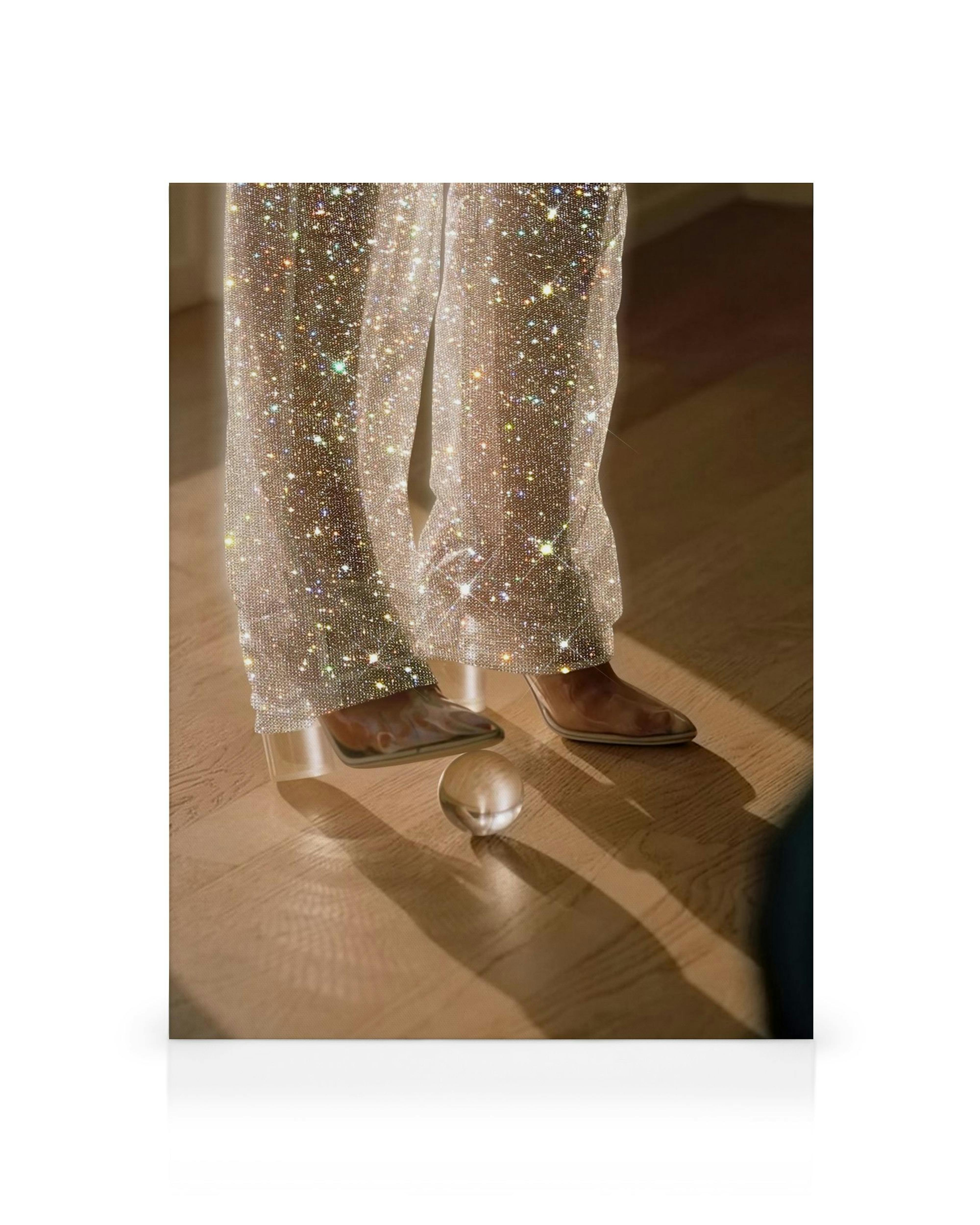 Toile: personne en pantalon scintillant, chaussures marron, avec une boule transparente et des jeux de lumière.