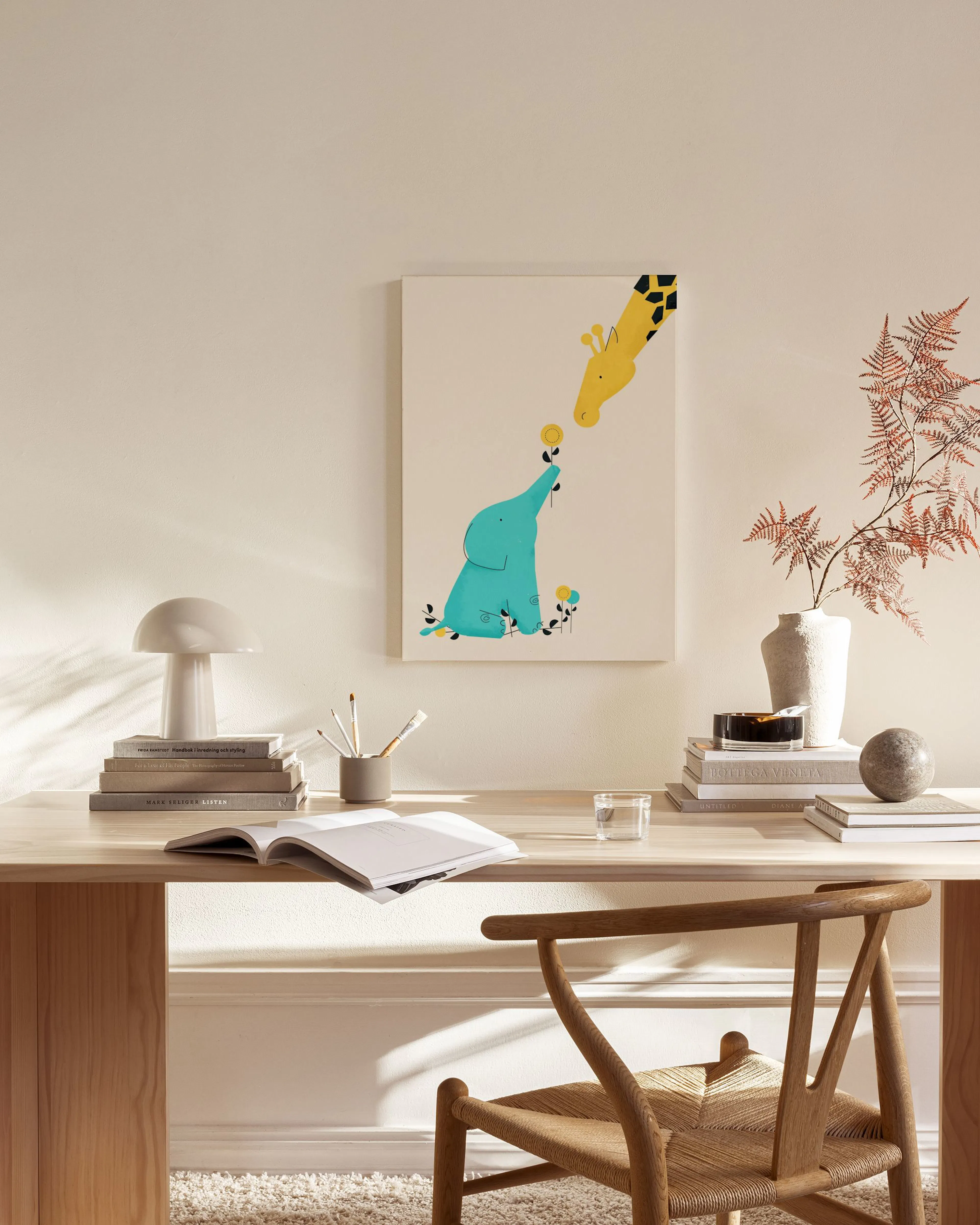 Stampa su tela con elefante blu e giraffa gialla che si scambiano un fiore, appesa in un soggiorno moderno.