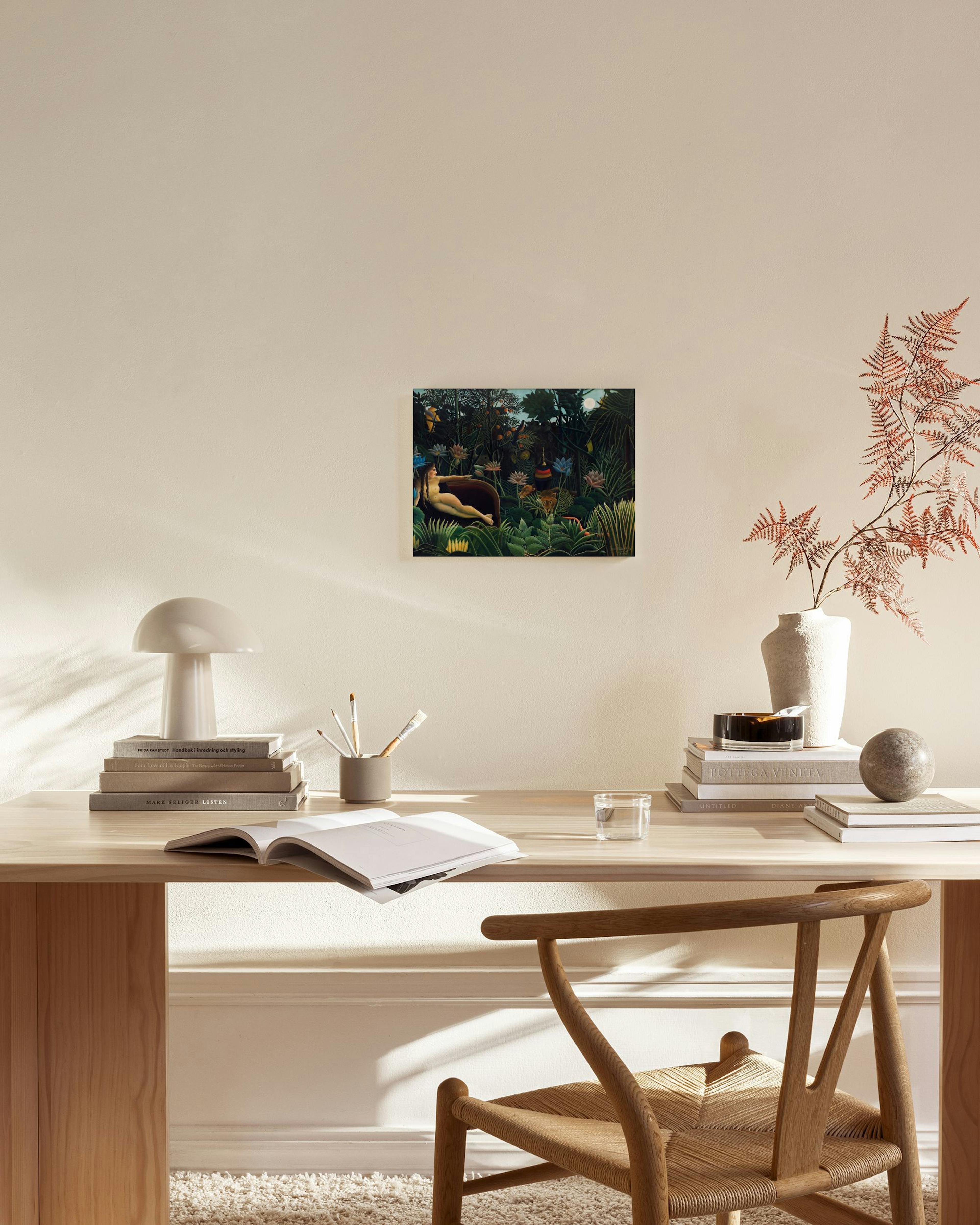 Lærred af en kvinde i en regnskov med løve, hængende over et lavt træmøbel i en moderne stue.