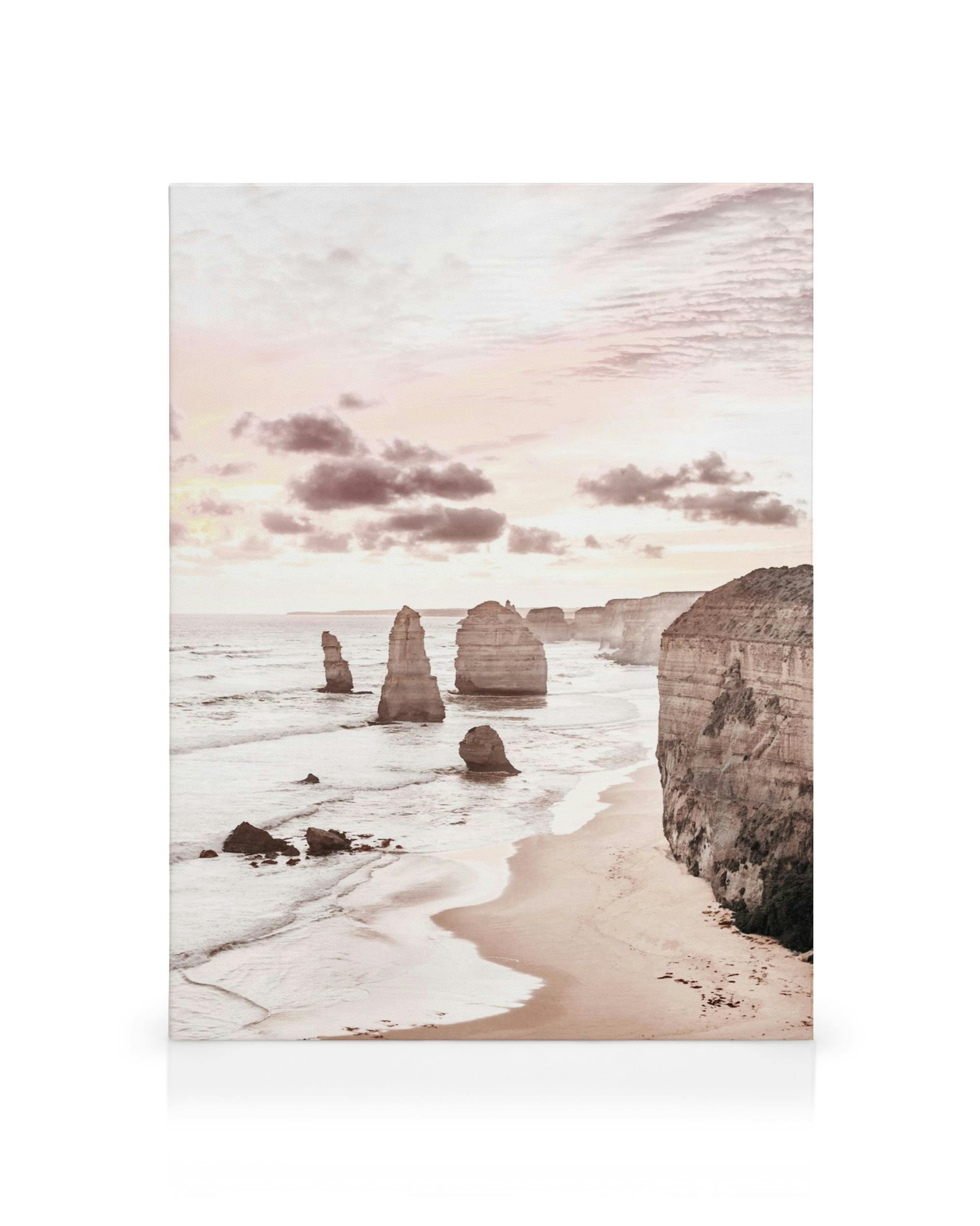 Obraz na plátne: západ slnka nad oceánom s útesmi a piesočnatou plážou v teplých tónoch.