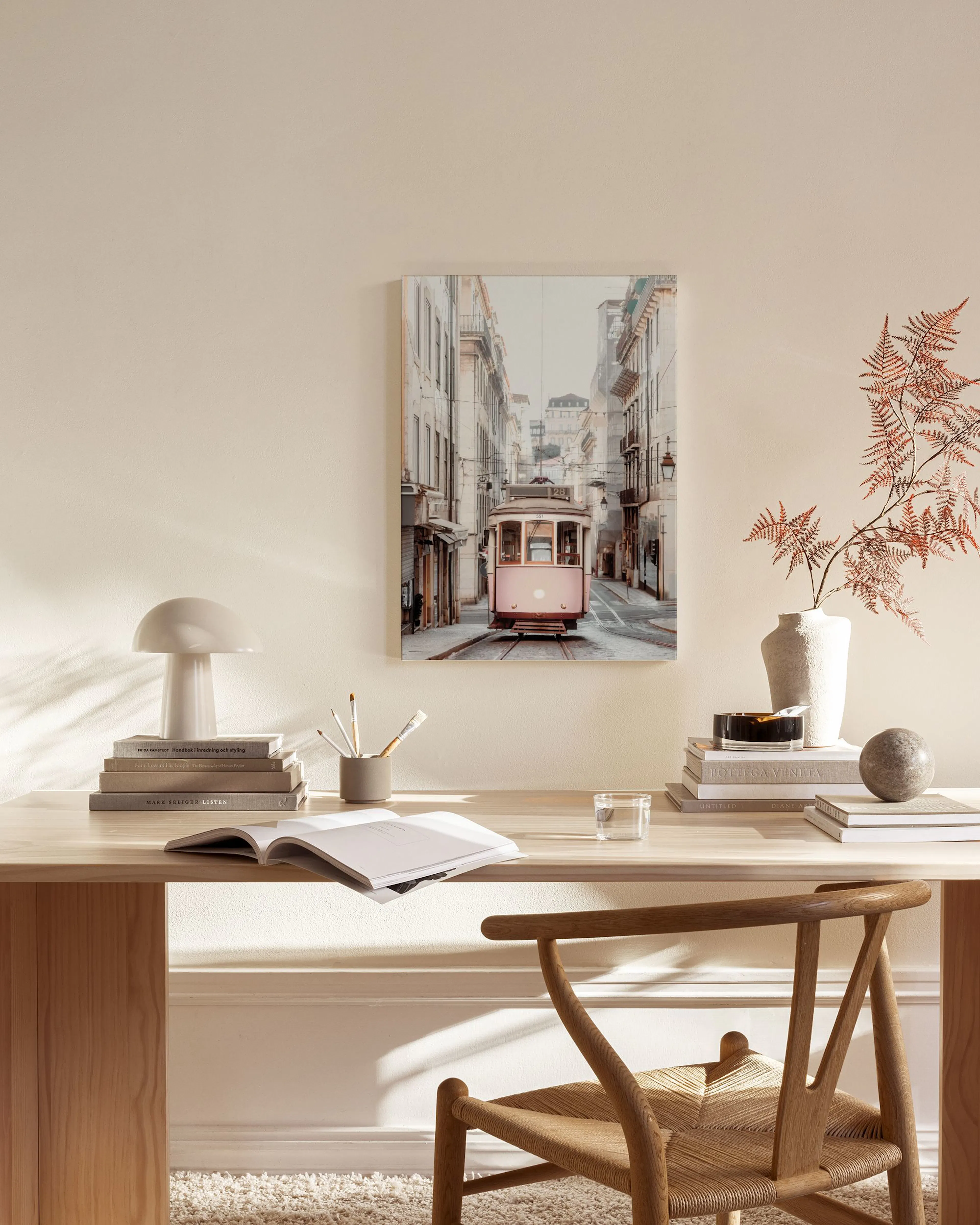 Toile dun tramway rose à Lisbonne sur une rue pavée, accrochée au-dessus dun banc en bois dans un salon moderne.