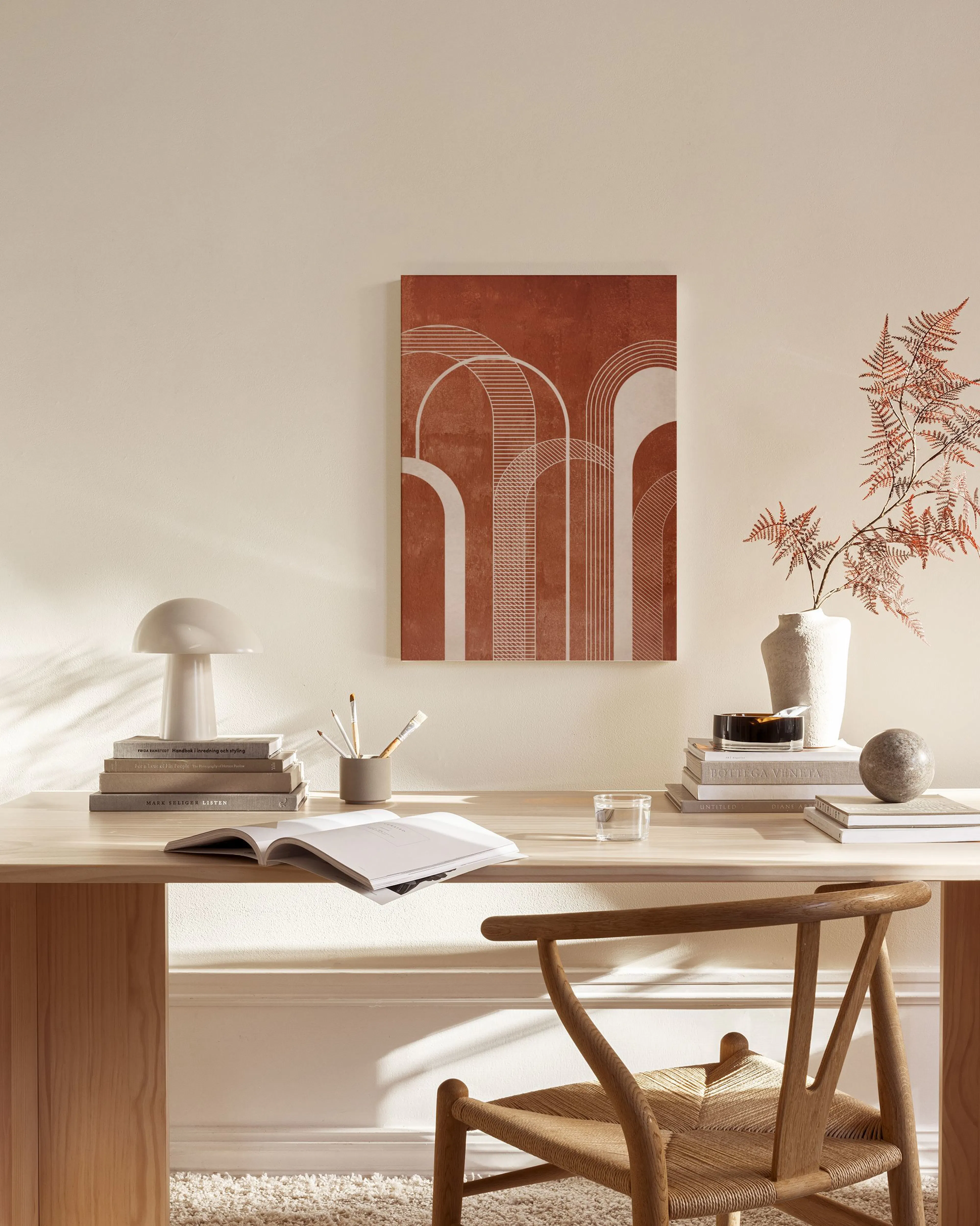 Toile terracotta avec des arches blanches et des lignes courbées, suspendue dans un salon moderne au-dessus dun meuble bas en bo