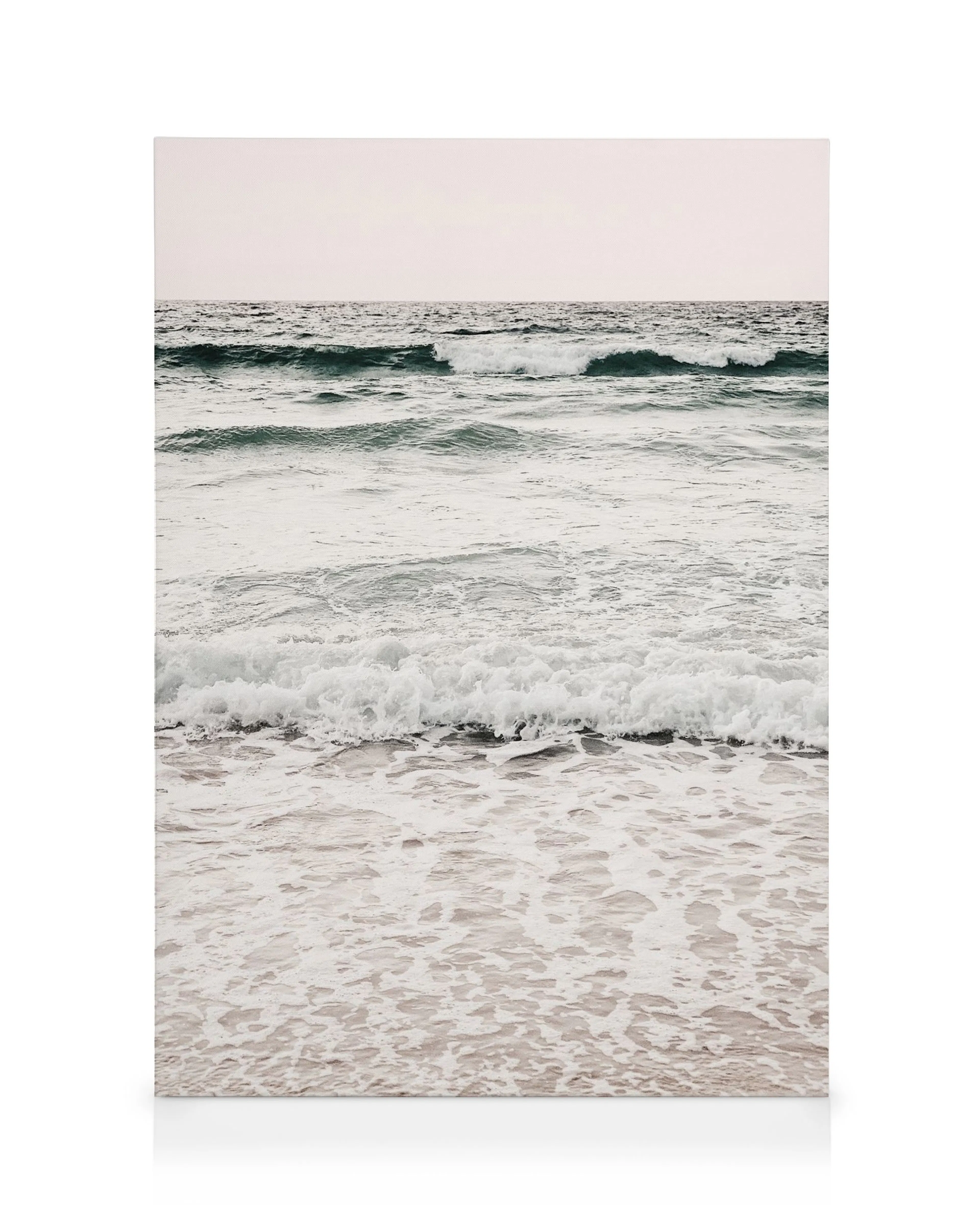 Calming Waves canvas print, featuring serene ocean waves with white foam against a pale sky, ideal for coastal decor.
