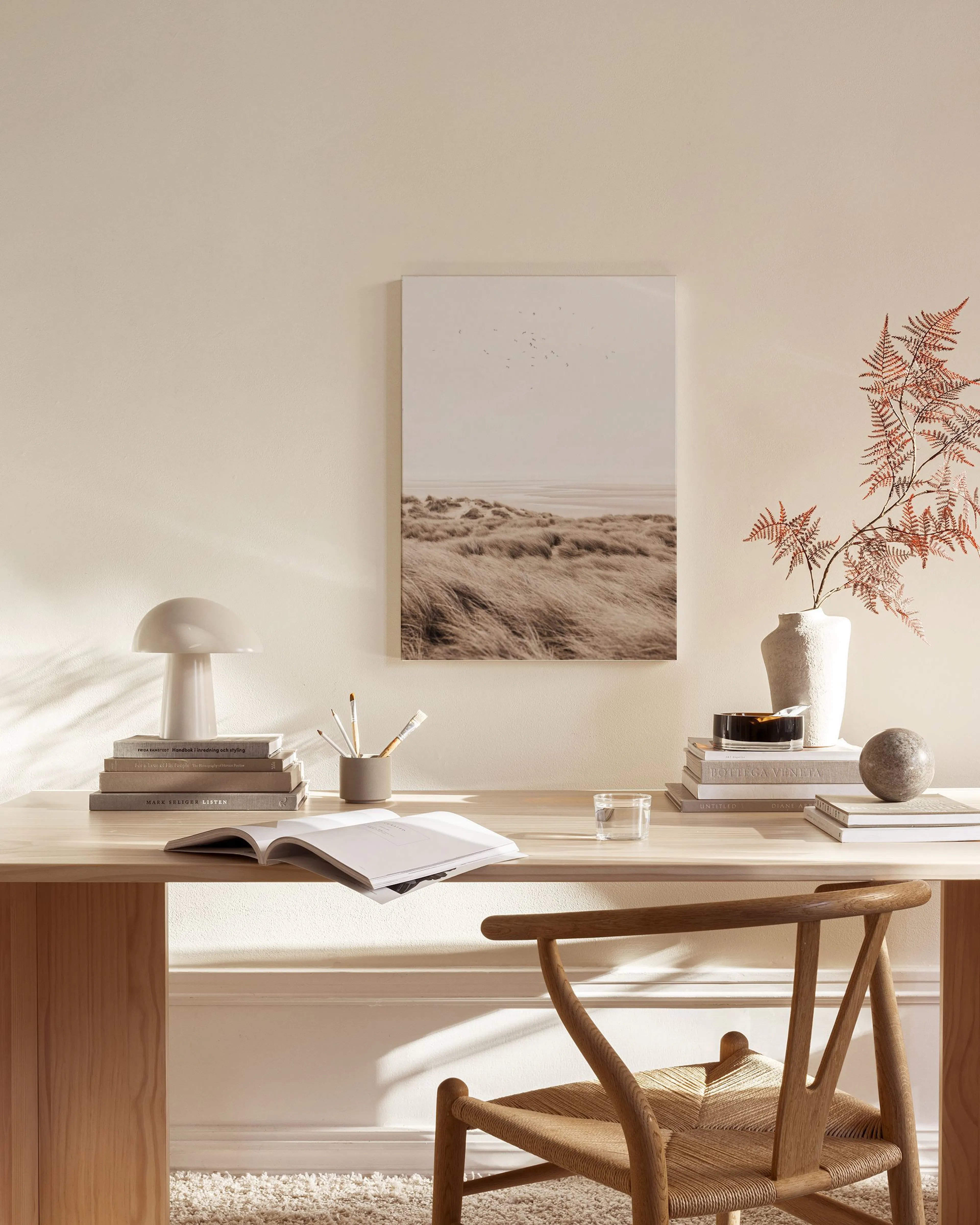 Leinwandbild einer Dünenlandschaft im Herbstton mit fliegenden Vögeln, hängt in einem modernen Wohnzimmer.