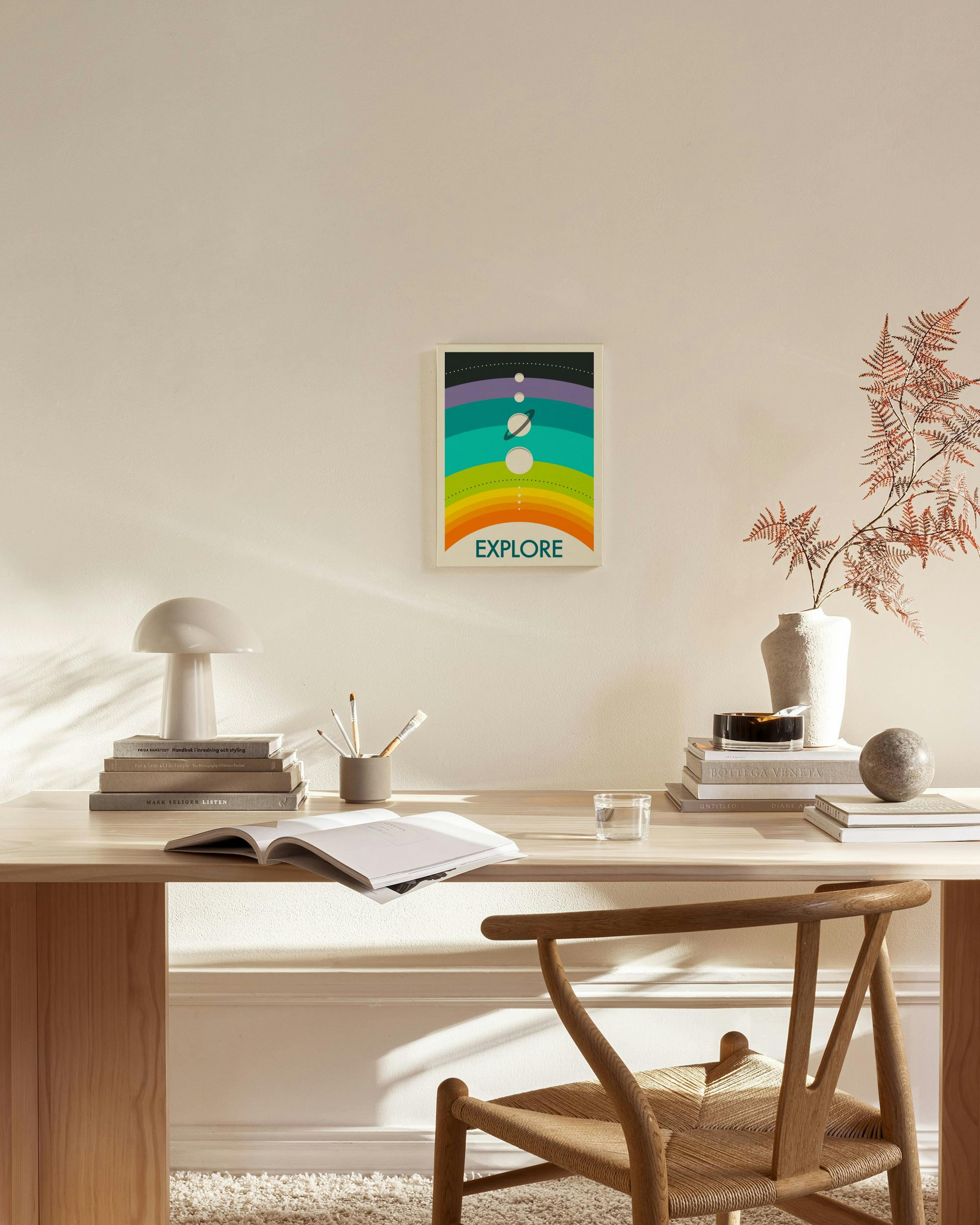 Leinwandbild mit bunten Regenbogenstreifen und Planetenmotiven, Text EXPLORE, über einem Sideboard im Wohnzimmer.