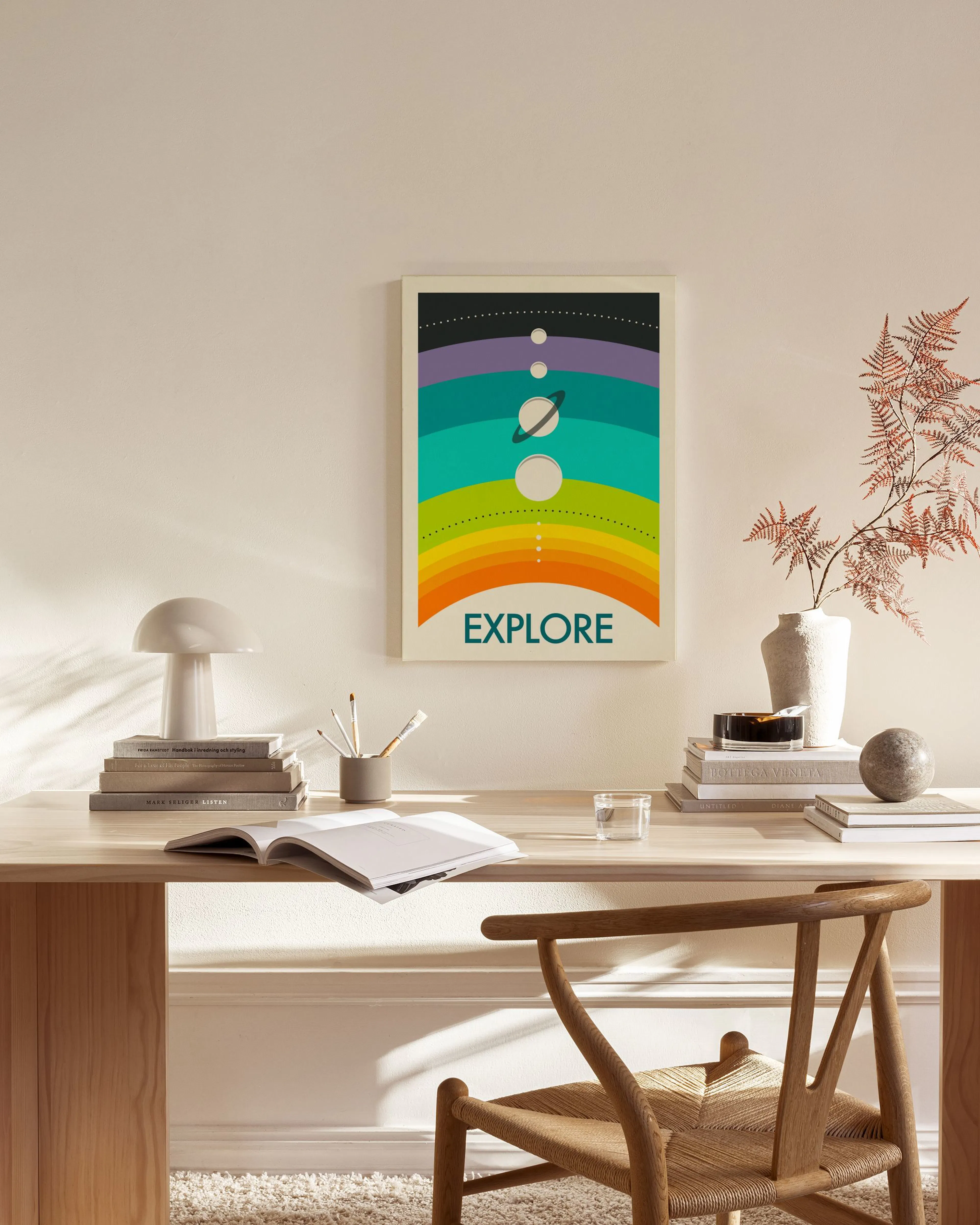 A colorful solar system print with the word EXPLORE below, hanging in a bright, modern living room.