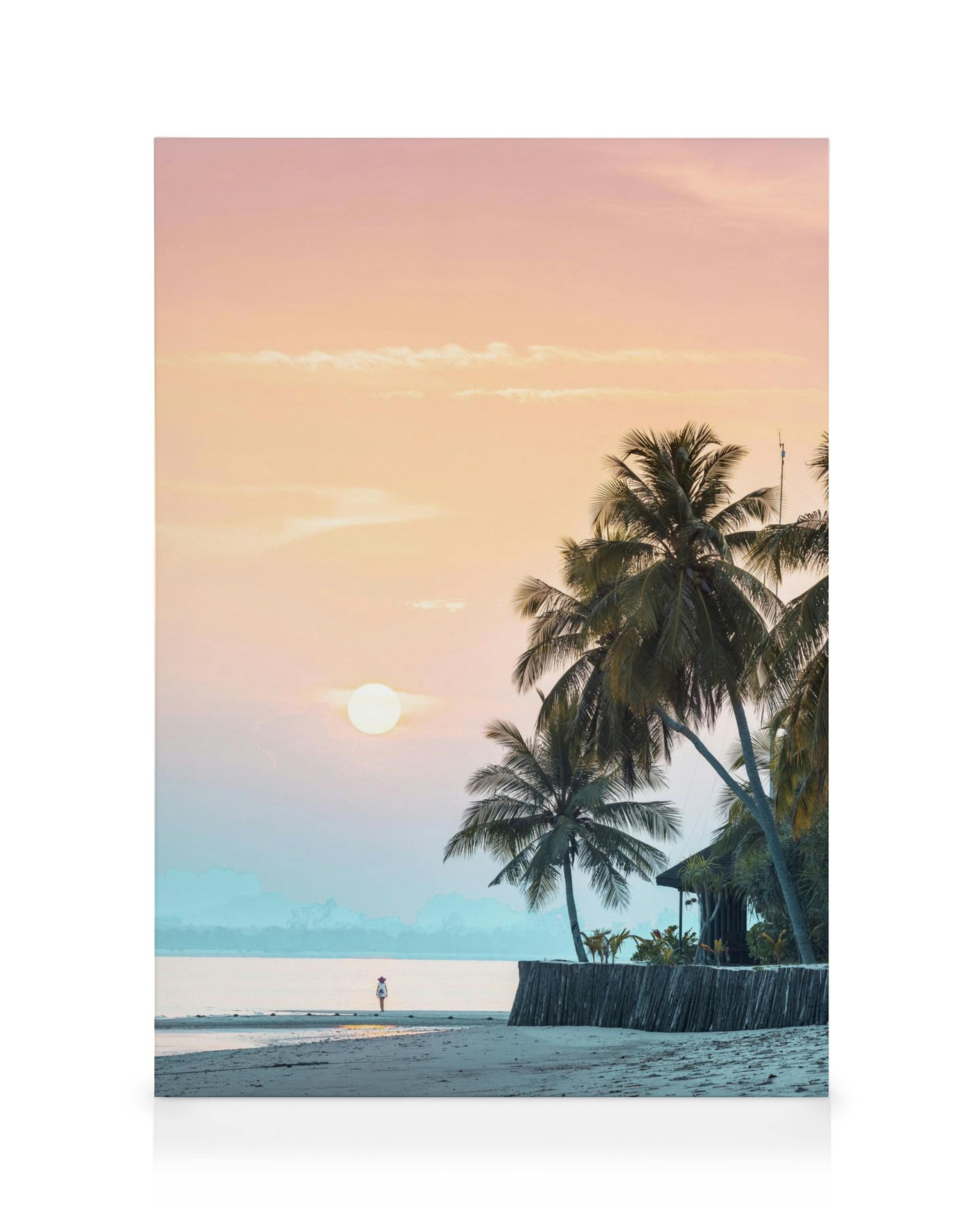 Lienzo de playa al atardecer con cielos rosados y azules, sol brillante y palmeras en silueta.