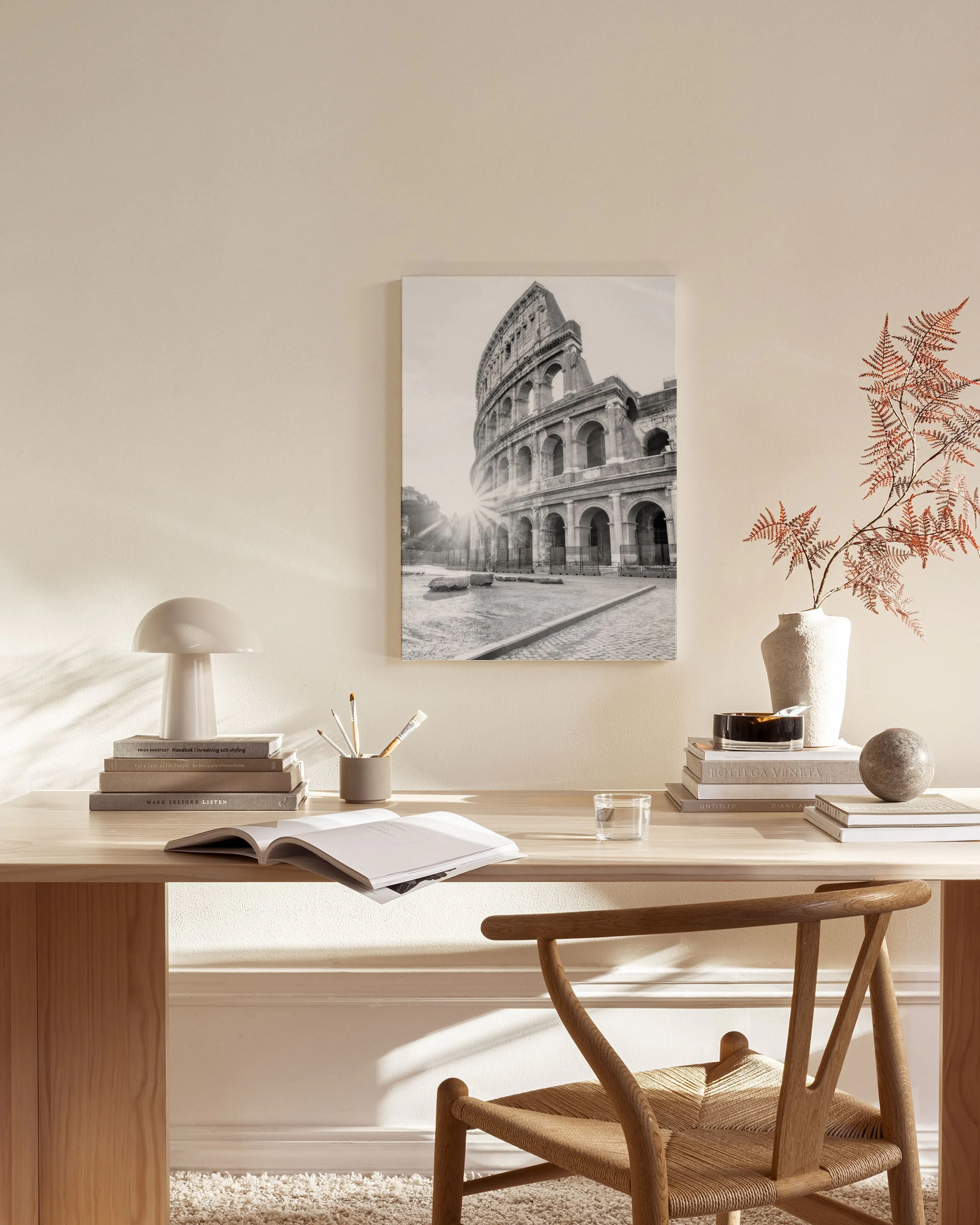 Schwarz-weiß Leinwandbild des Kollosseums mit Sonnenstrahlen, hängend über einem Sideboard im Wohnzimmer.