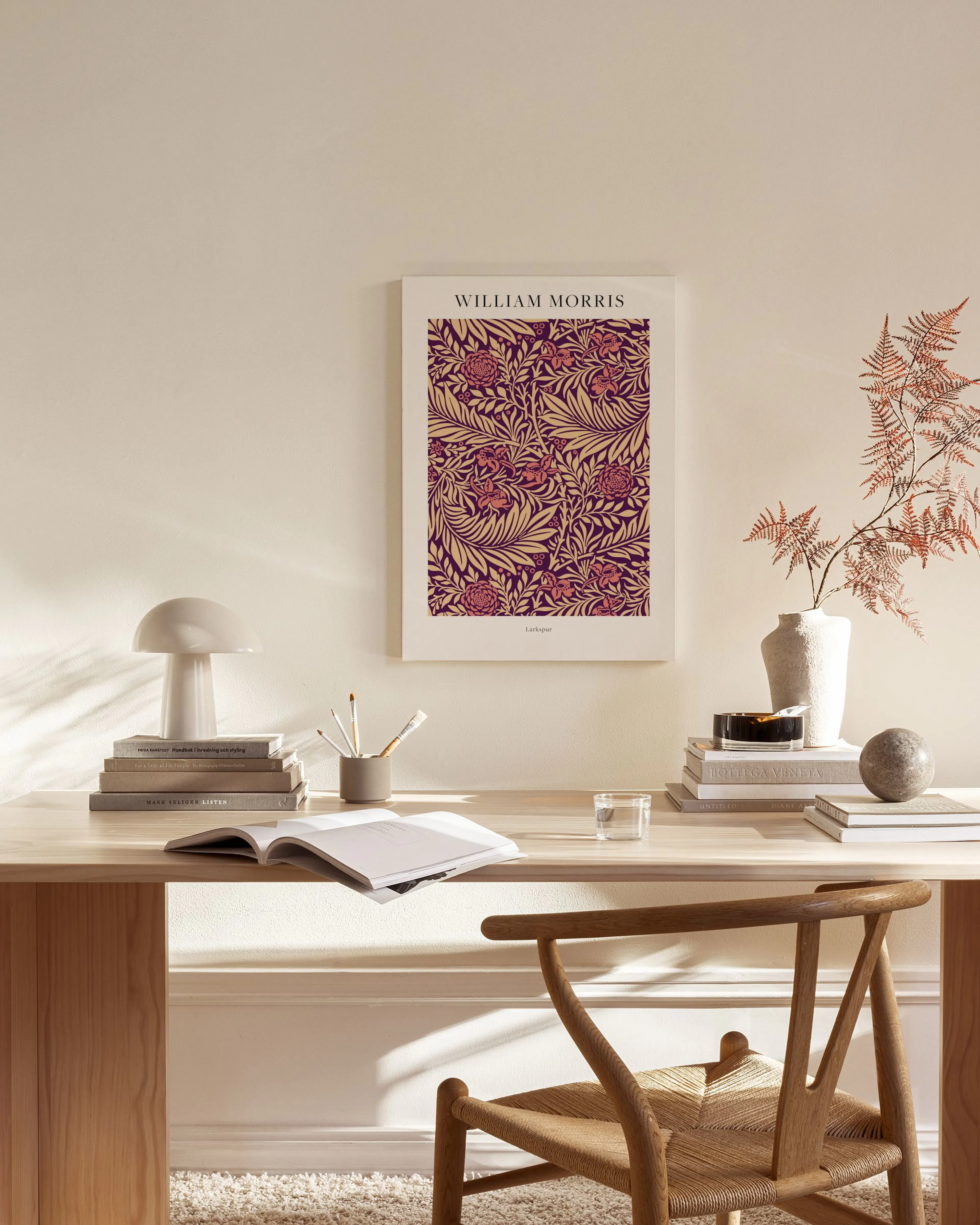 A William Morris Larkspur print with deep purple and golden floral patterns, hanging in a bright, modern living room.