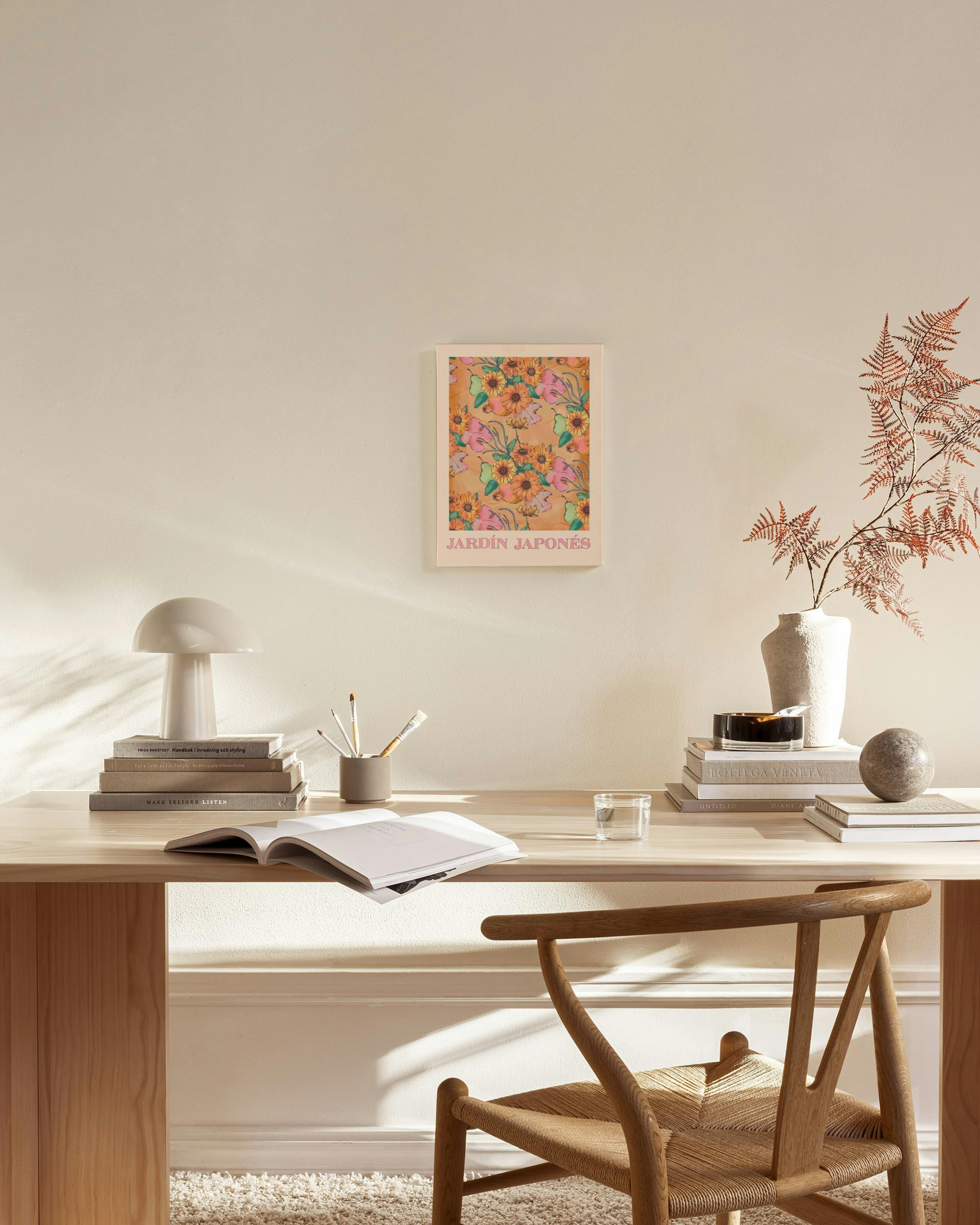 Leinwandbild mit orangen Blumen und rosa Blättern, hängt über einem Holzschrank in einem hellen Wohnzimmer.