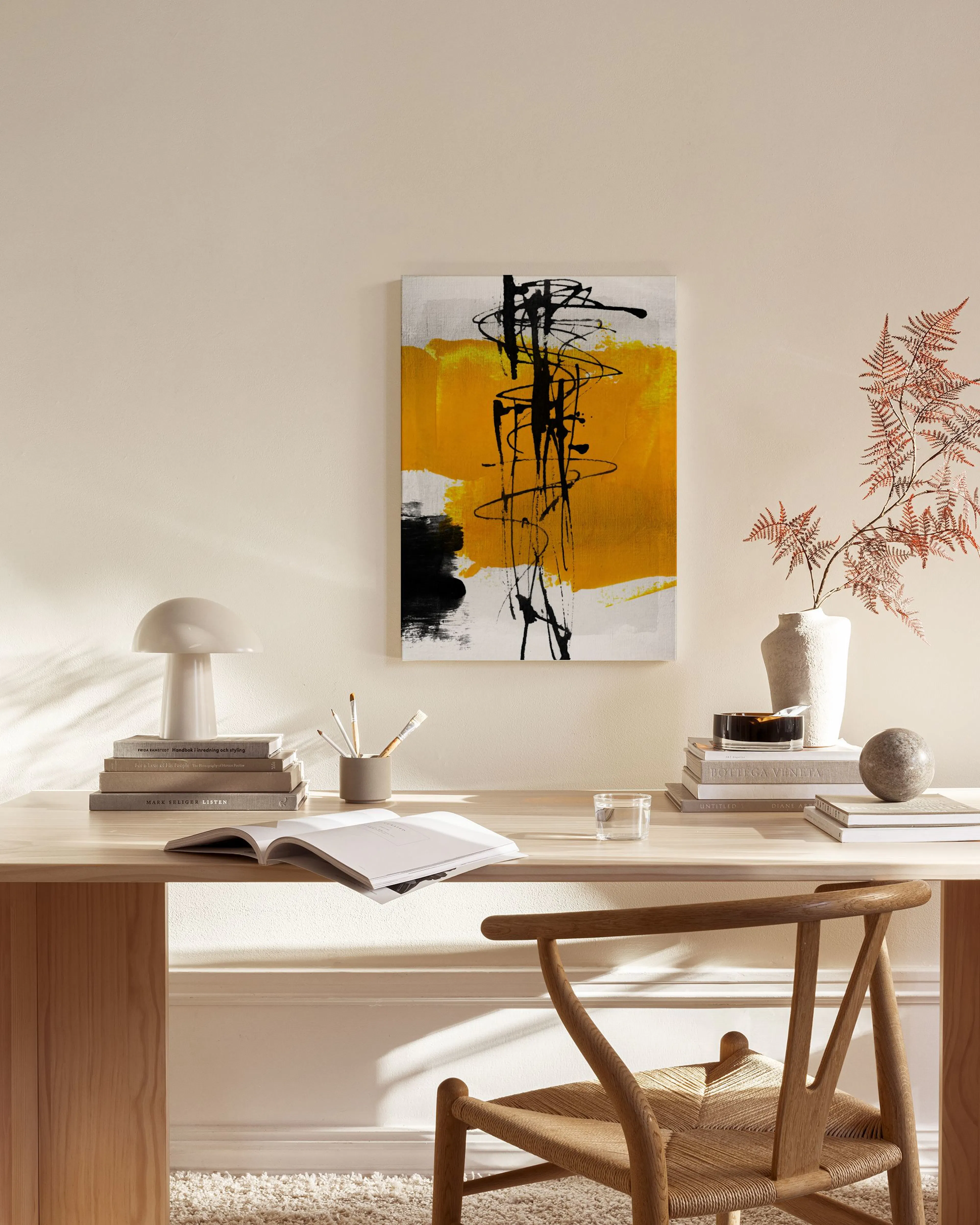 Abstract canvas print with a vibrant yellow background and bold black brushstrokes and lines, on a white background.