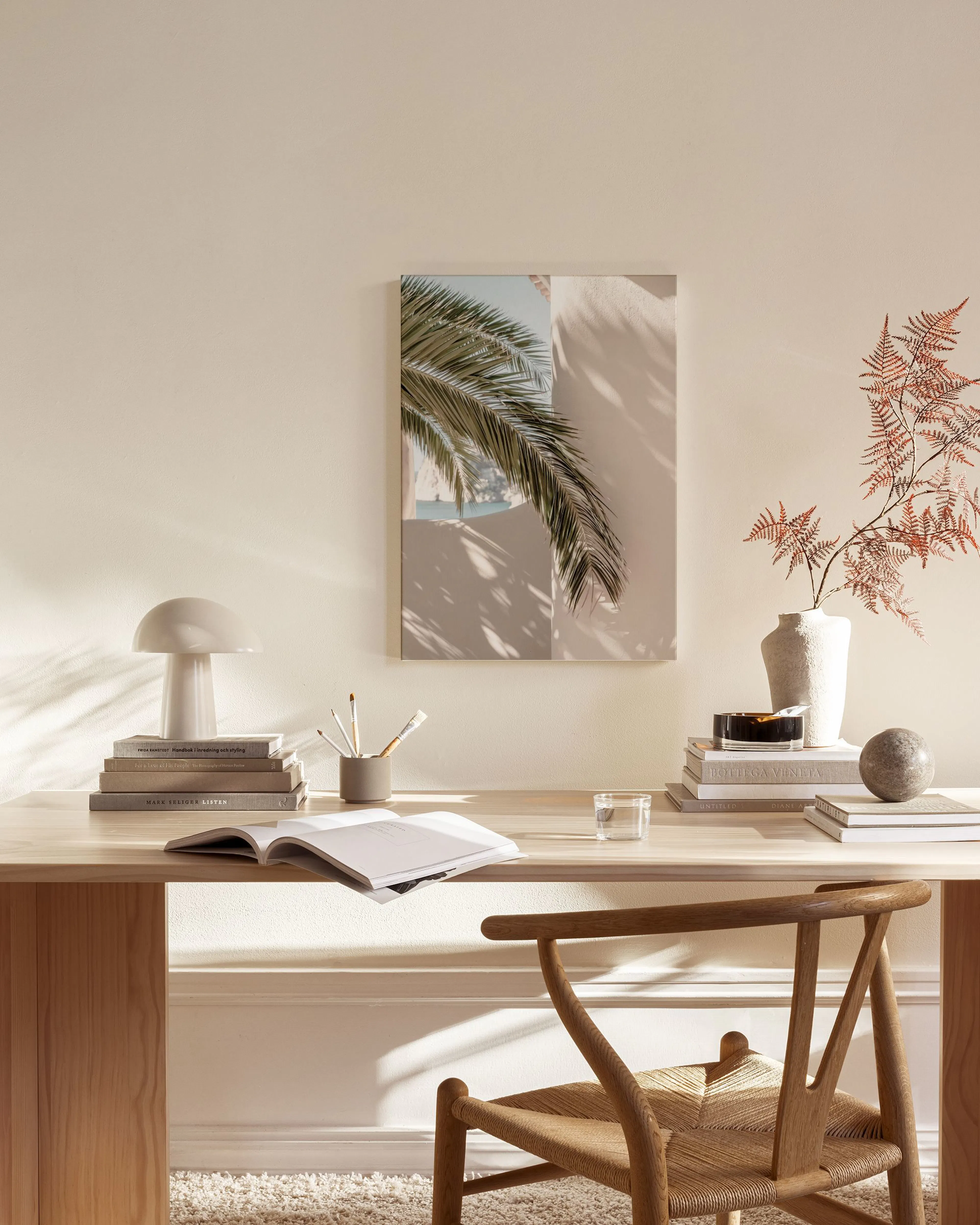 Leinwandbild einer Palme mit Schatten auf einer weißen Wand, in einem modern eingerichteten Wohnzimmer über einem Sideboard.